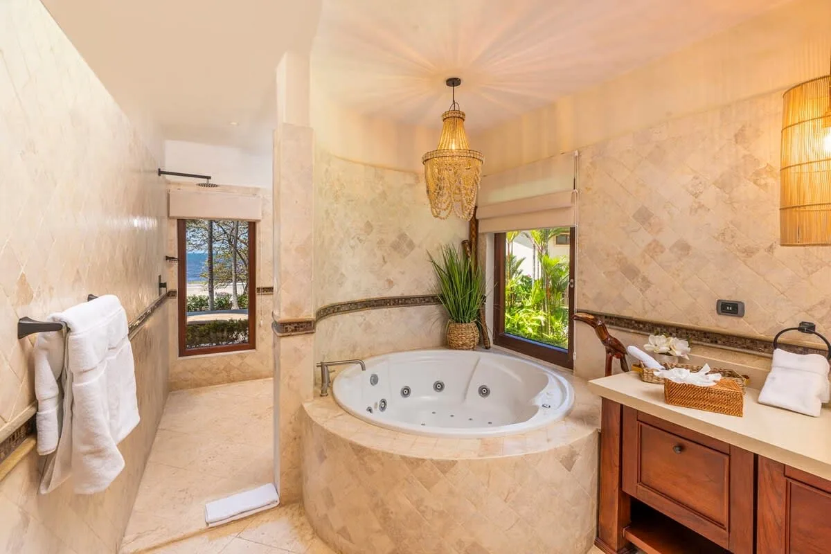 A bright bathroom with a round soaking tub and a wood vanity.