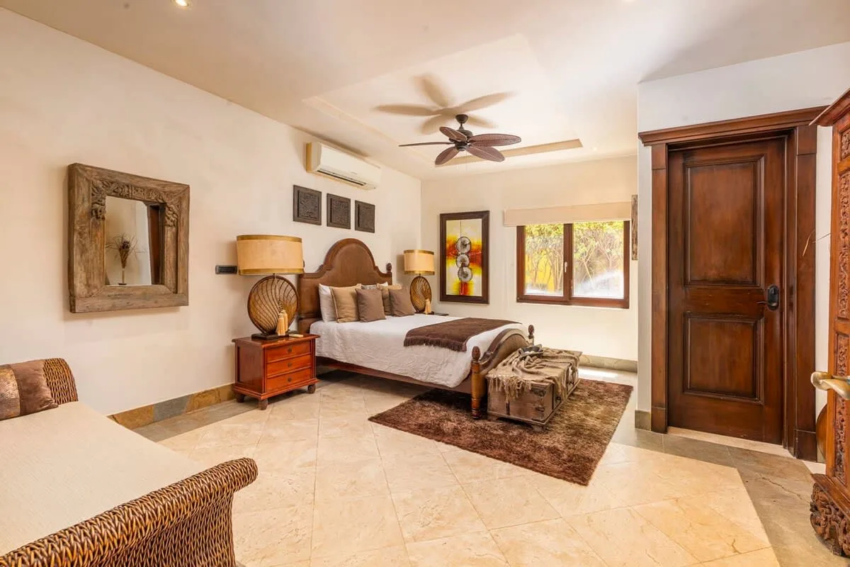 A bedroom with a bed, bedside tables, and a window.