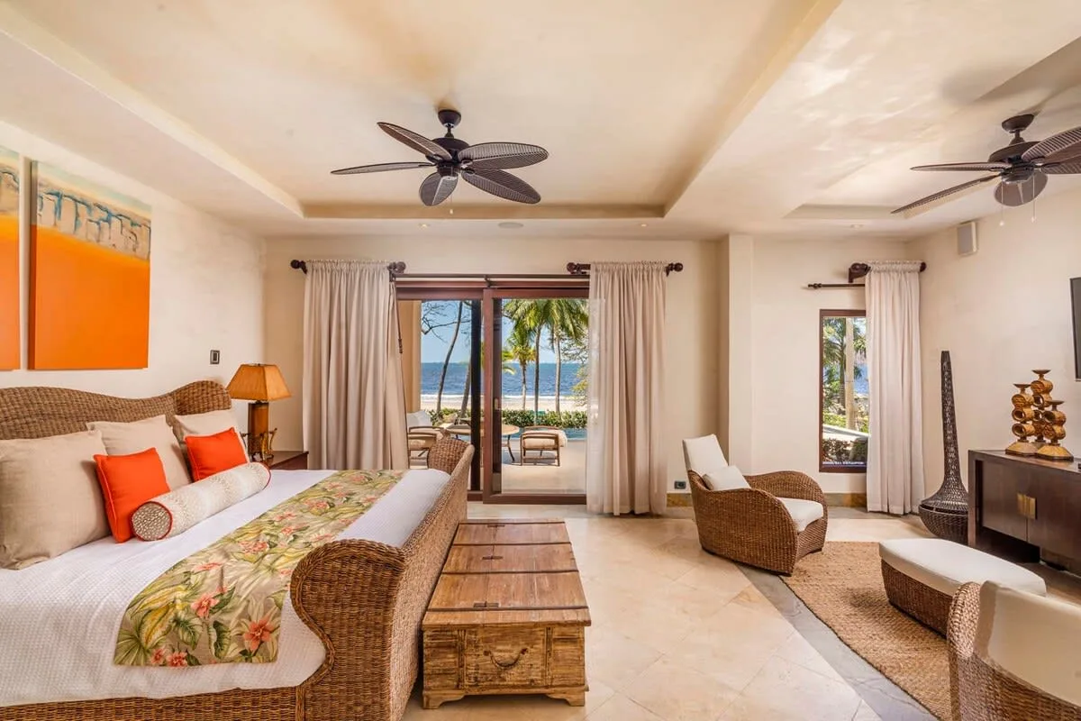 A bright bedroom opens onto a balcony with views of the water.