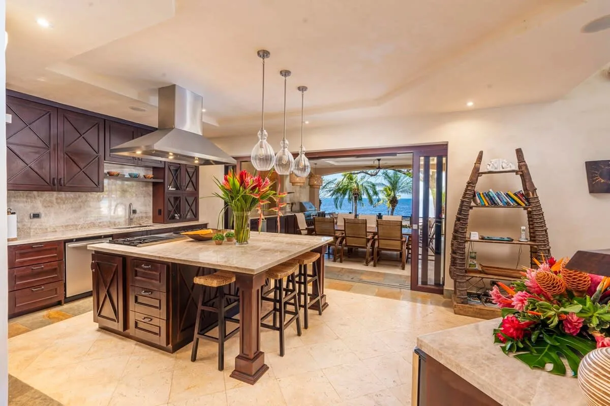 An open kitchen and dining area with a large island and view of the water.