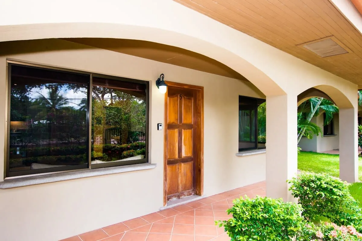 Shared amenity: A covered entrance with a wooden door opens onto a garden.