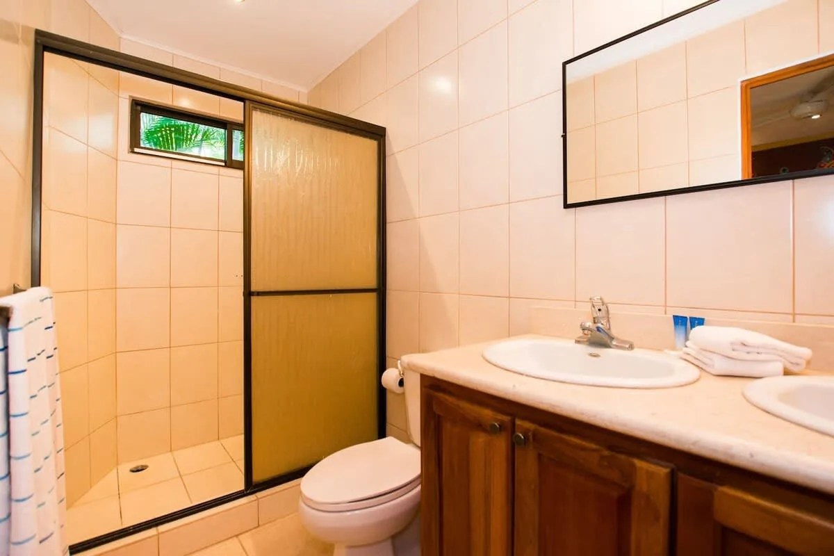 A tiled bathroom with a shower, toilet, and sink vanity.