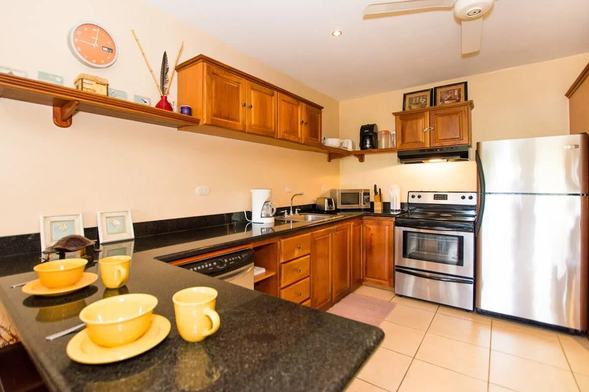 A kitchen with wooden cabinets, a stove, and a refrigerator.