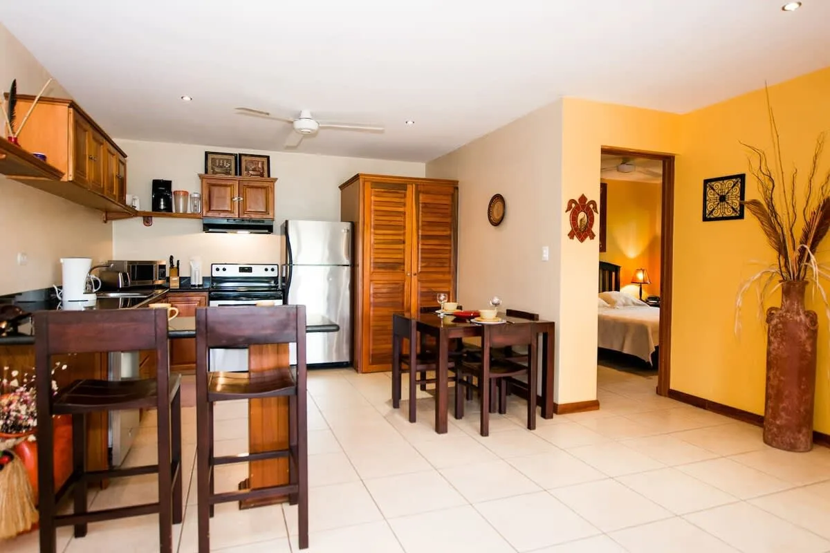 An open-plan kitchen and dining area with a small table and chairs.