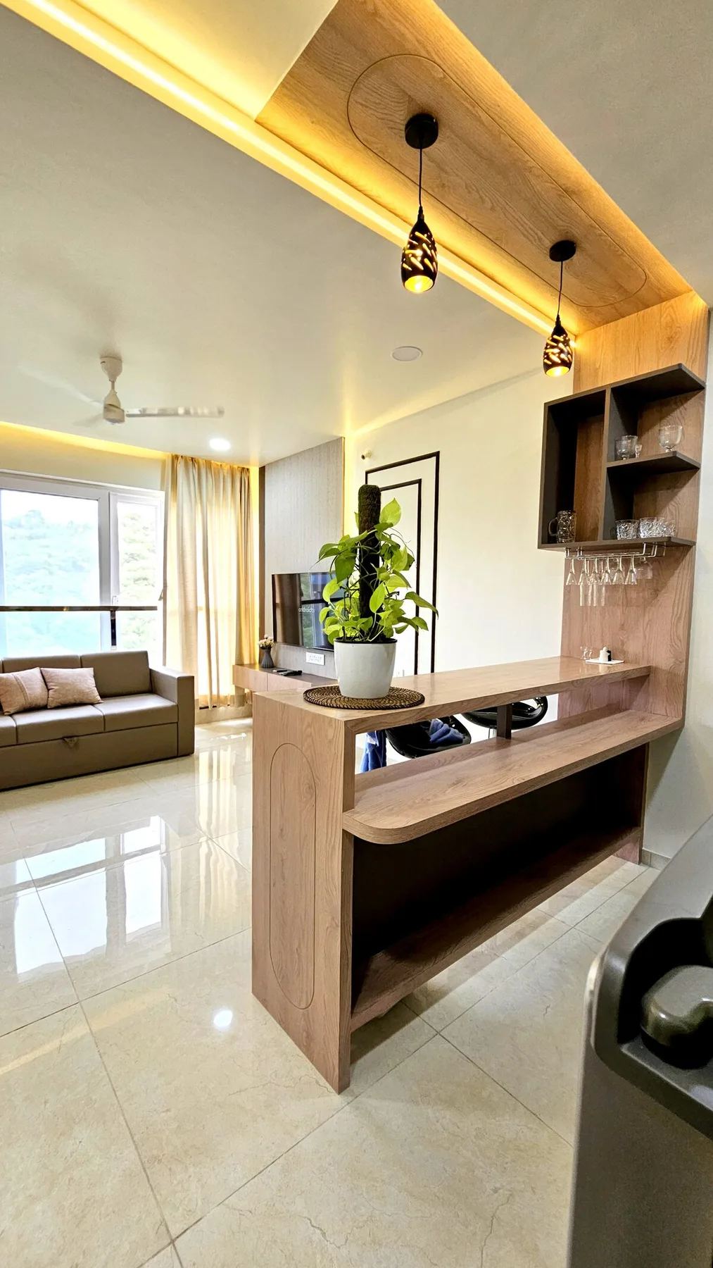 Una sala luminosa con una barra de madera y lámparas colgantes.