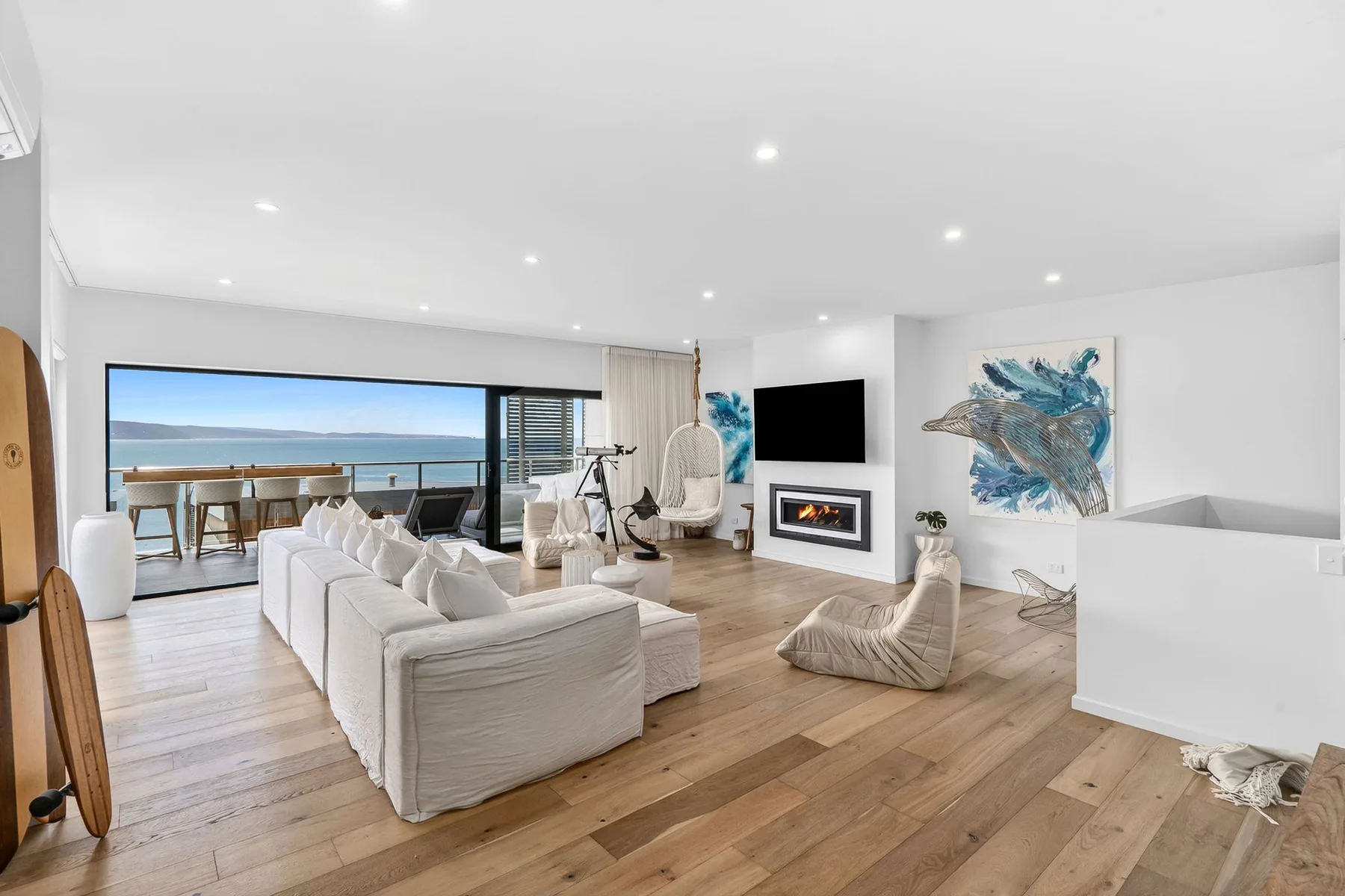 Una sala luminosa da a un balcón con vistas al mar.