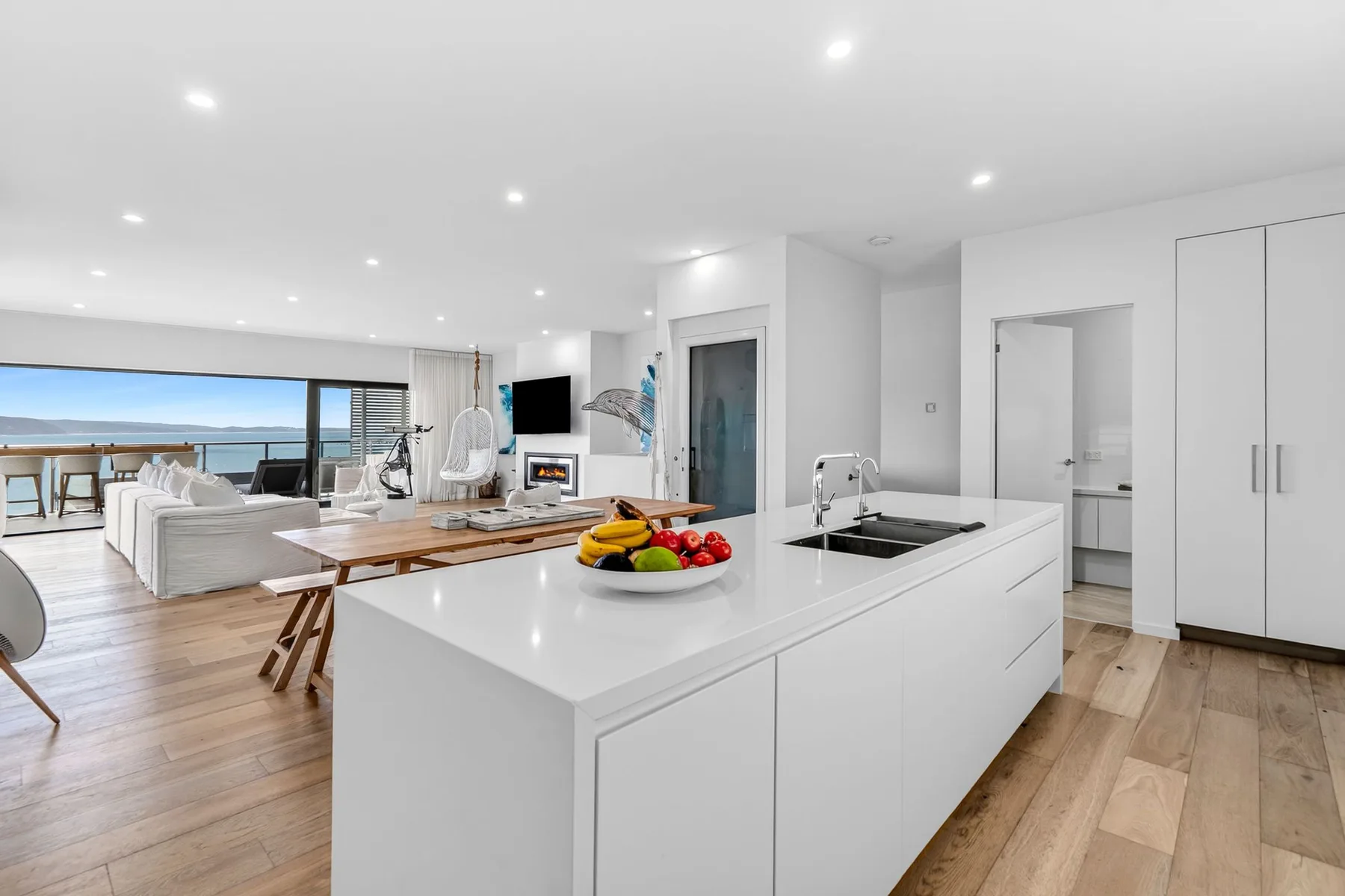 Una luminosa cocina abierta al salón, con una isla amplia y vistas al mar.