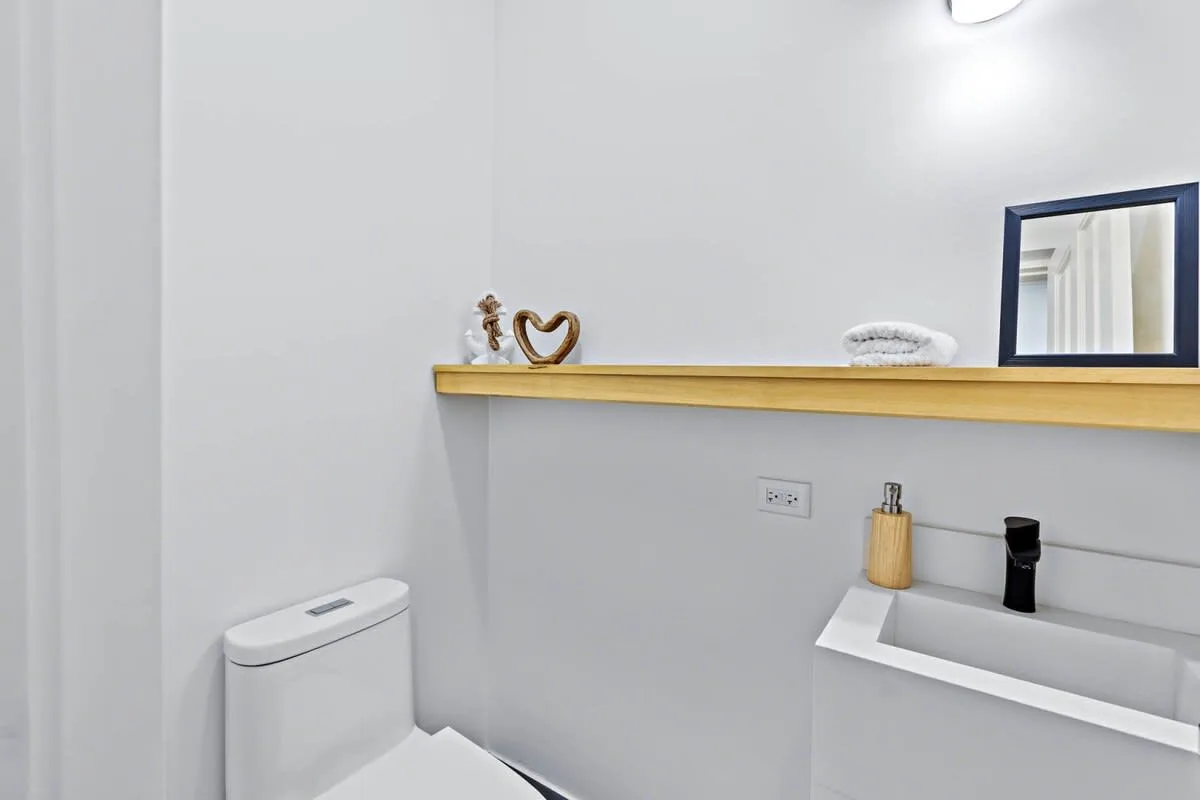 A bright bathroom with a white toilet and a wall-mounted sink.