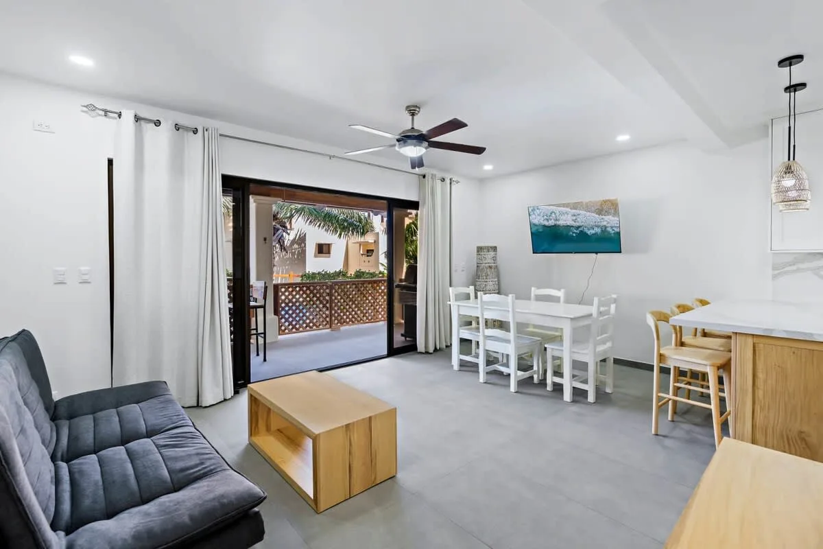 A bright living and dining area opens onto a furnished outdoor patio.