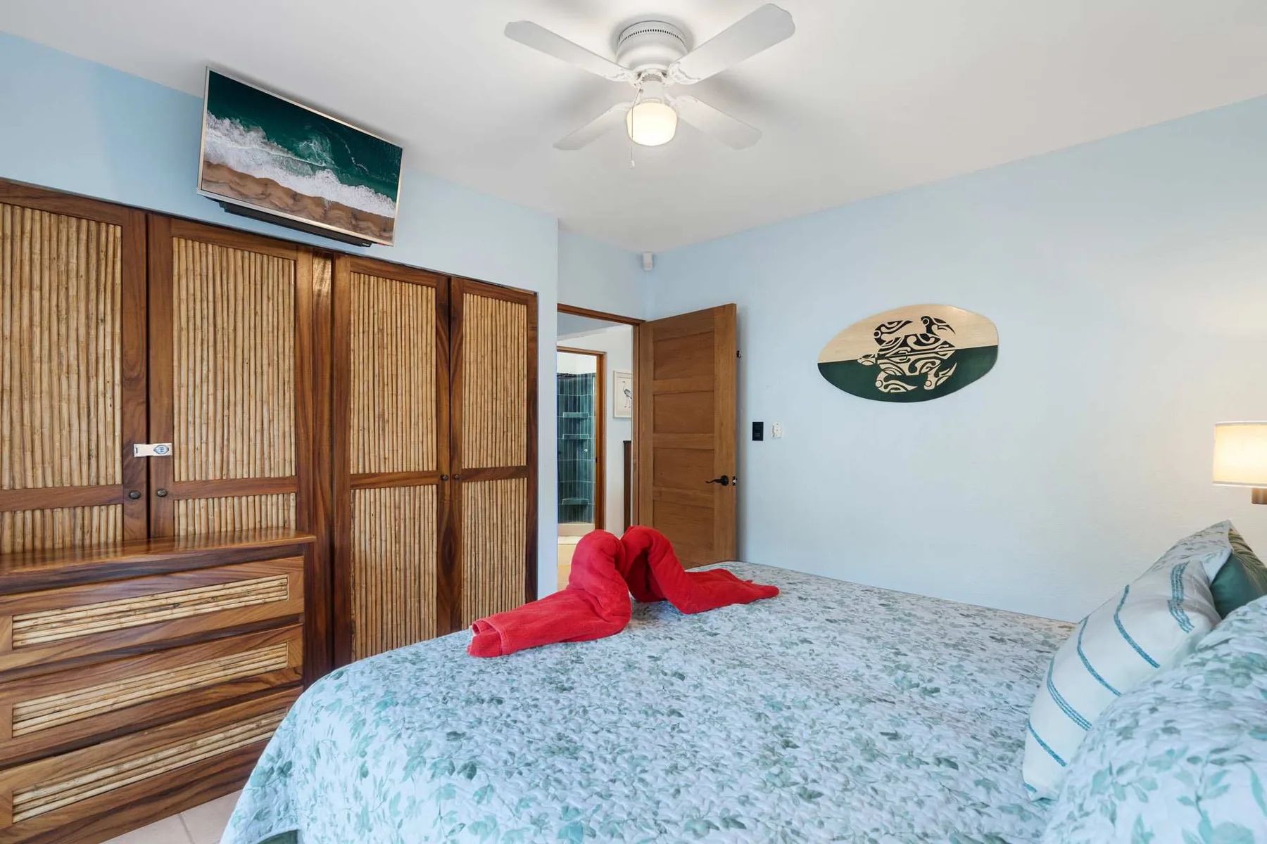 Un dormitorio con una colcha estampada y un armario de madera.