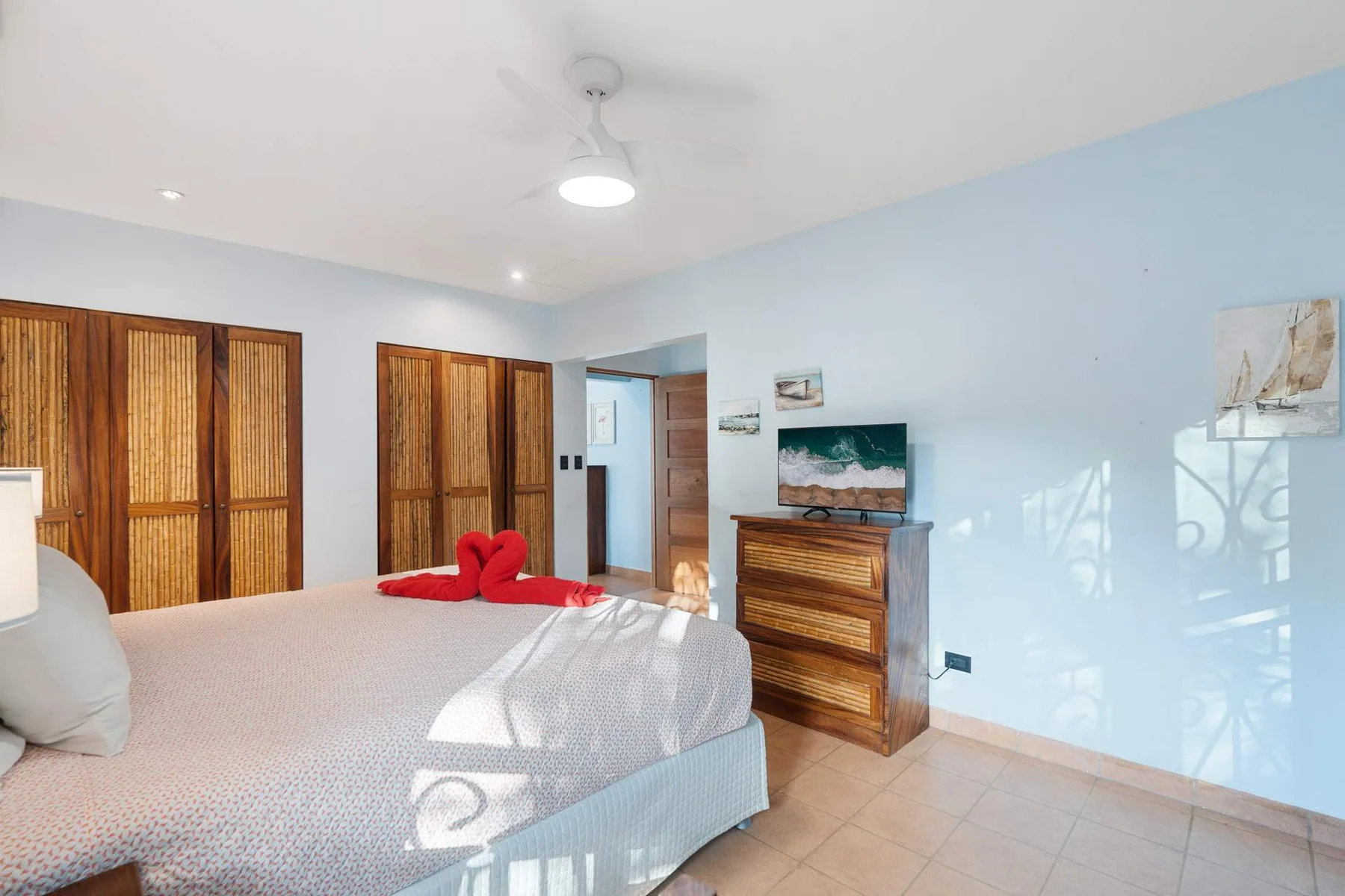 Un dormitorio con una cama, armarios de madera y una cómoda.