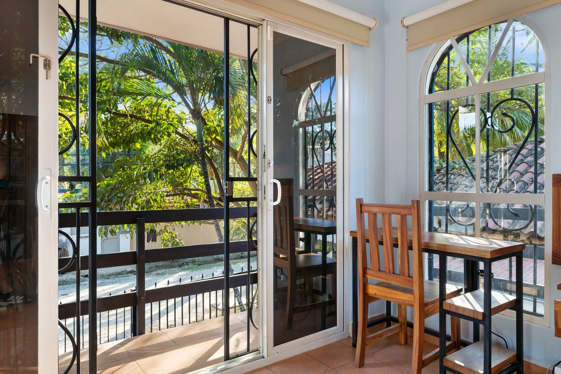 Un comedor luminoso con una mesa de madera junto a grandes ventanas con vistas a la vegetación.