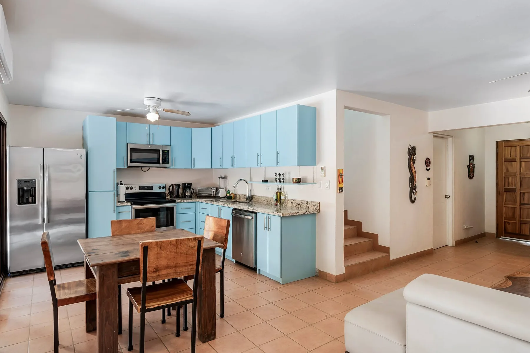 Kitchen and dining area with blue cabinets and a wooden dining table.