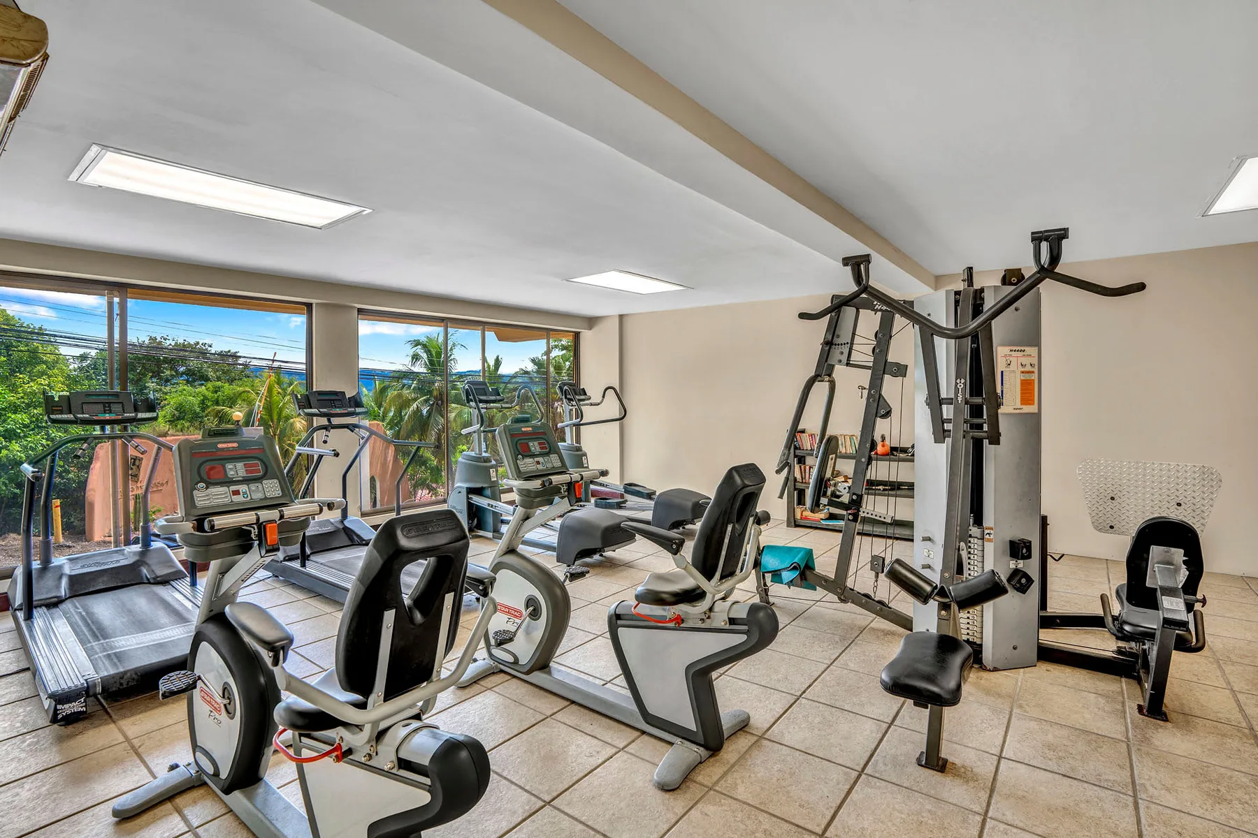 Shared amenity: A fitness room with exercise equipment and large windows.