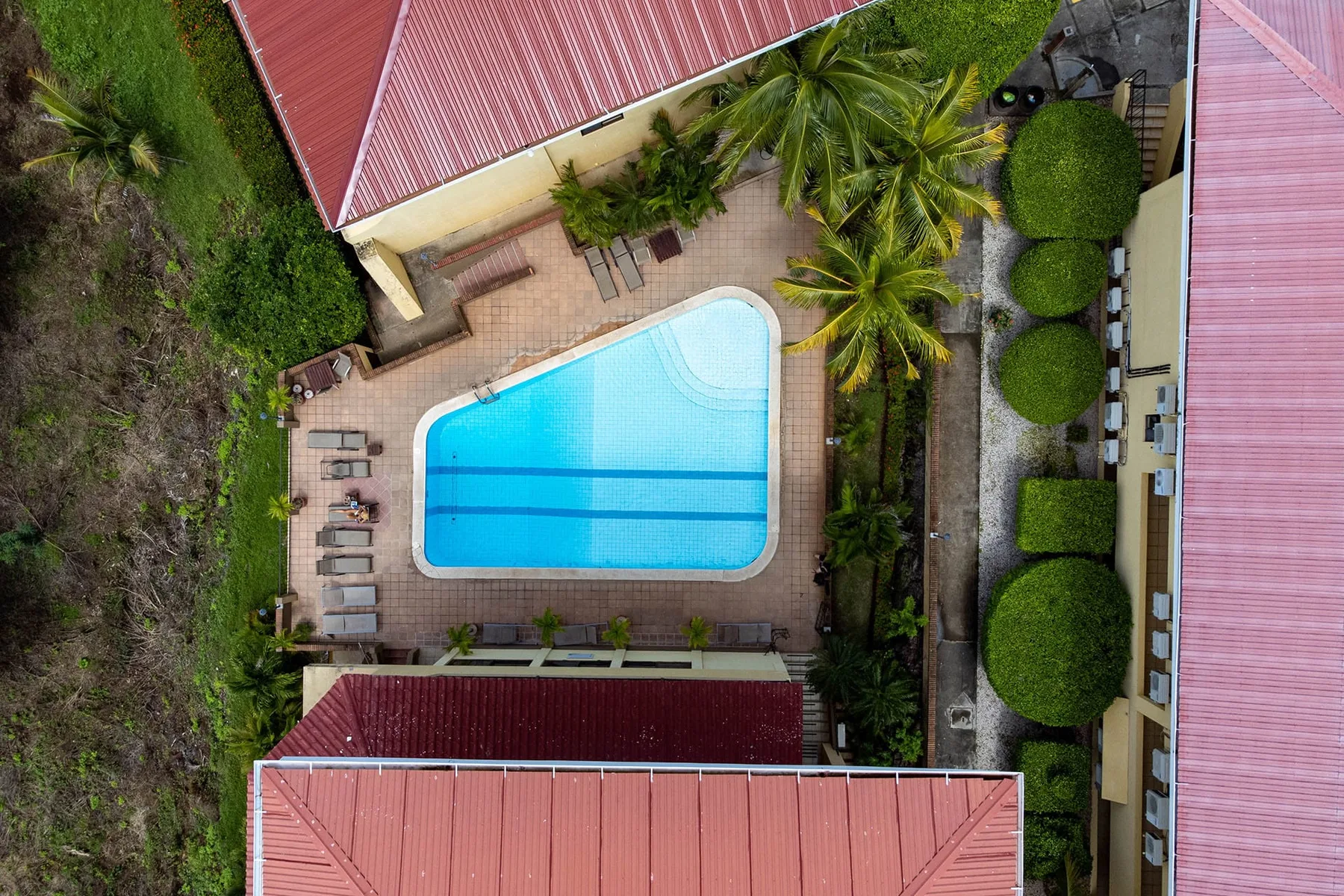 Shared amenity: Aerial view of a swimming pool beside buildings and landscaped grounds.