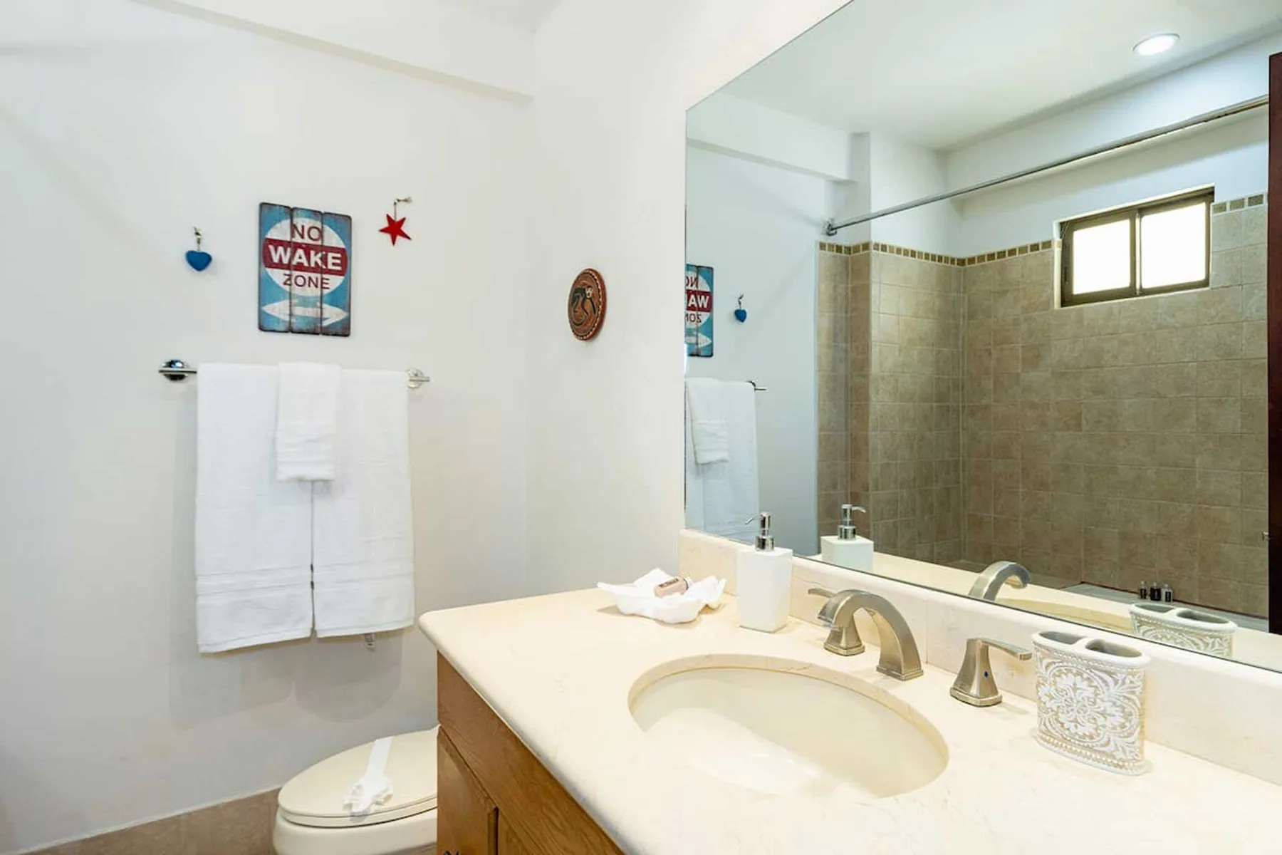 A bathroom with a sink vanity, mirror, and shower area.