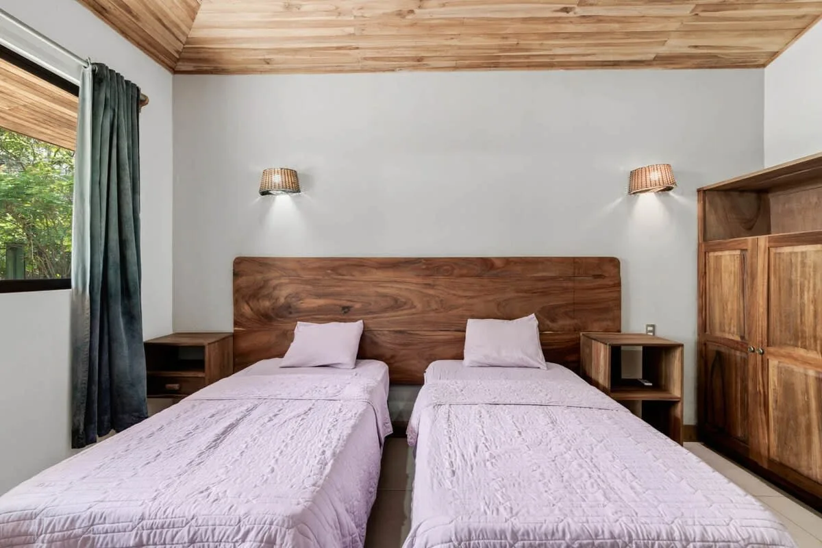 Un dormitorio con dos camas individuales, cabeceros de madera y mesas de noche.