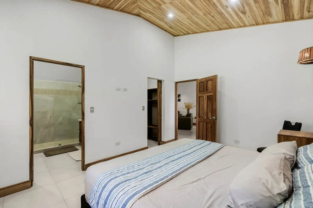 Un dormitorio con una cama y una puerta abierta.