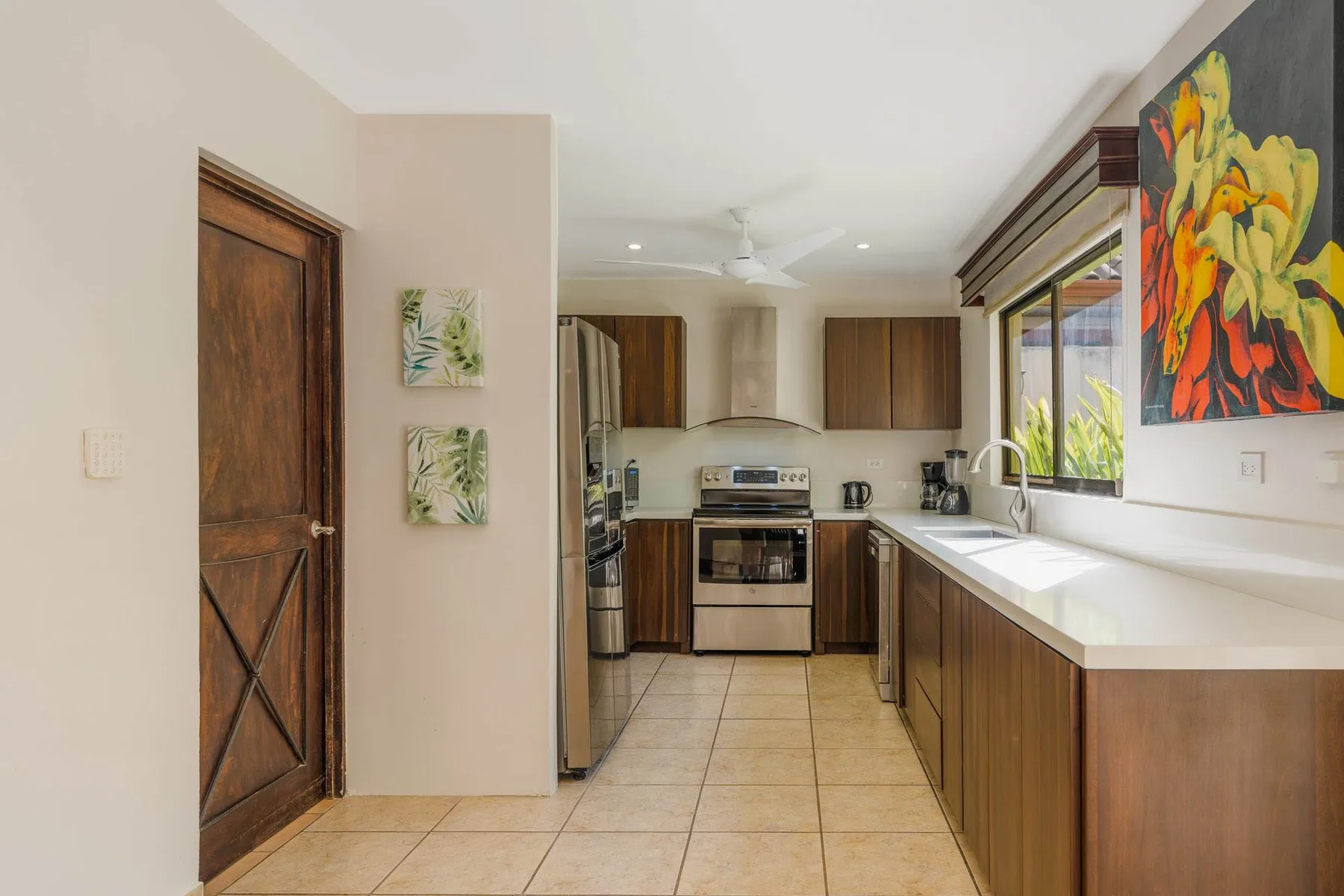 A kitchen with wooden cabinets, stainless steel appliances, and a long countertop.