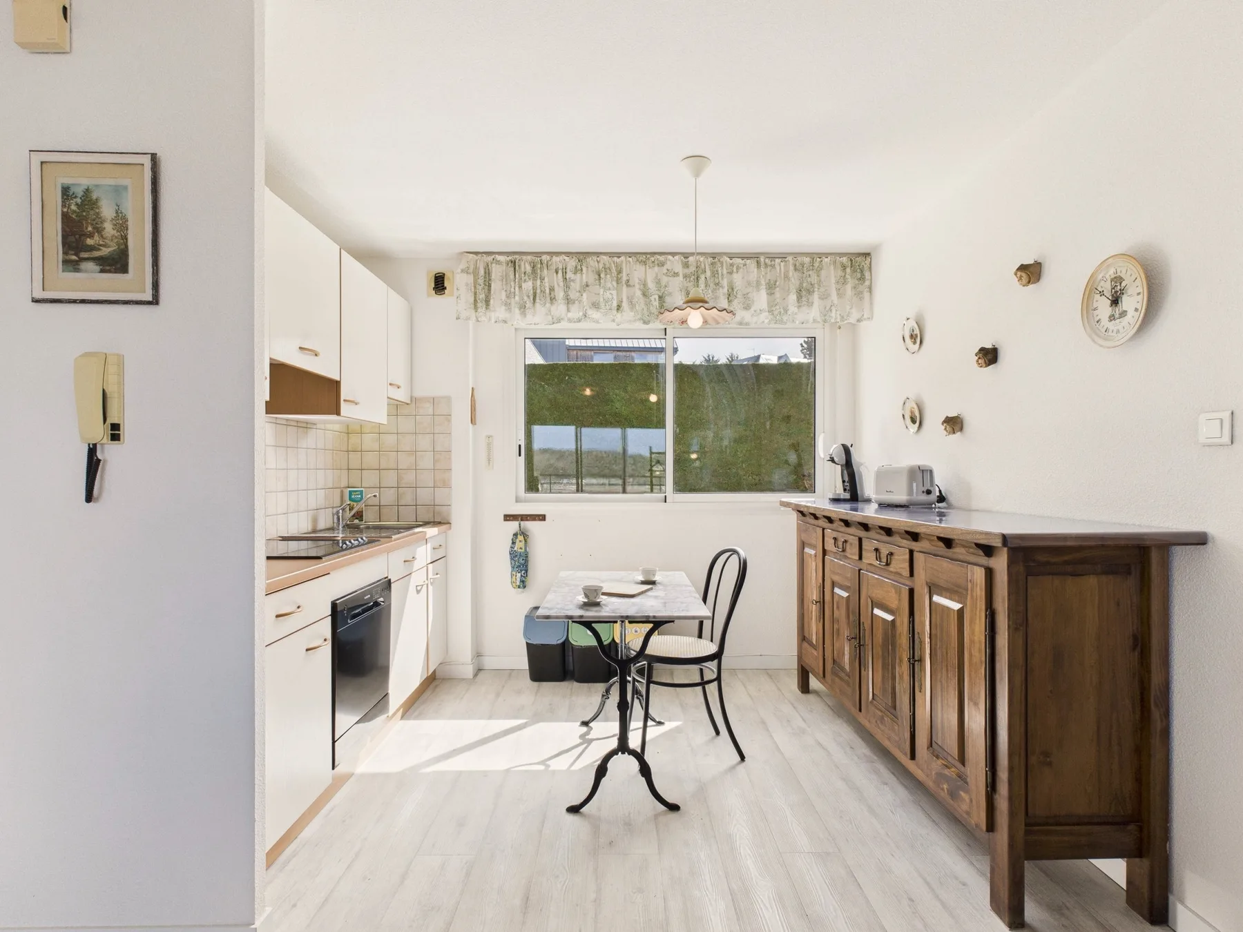 Una cocina luminosa con una mesa pequeña junto a la ventana.