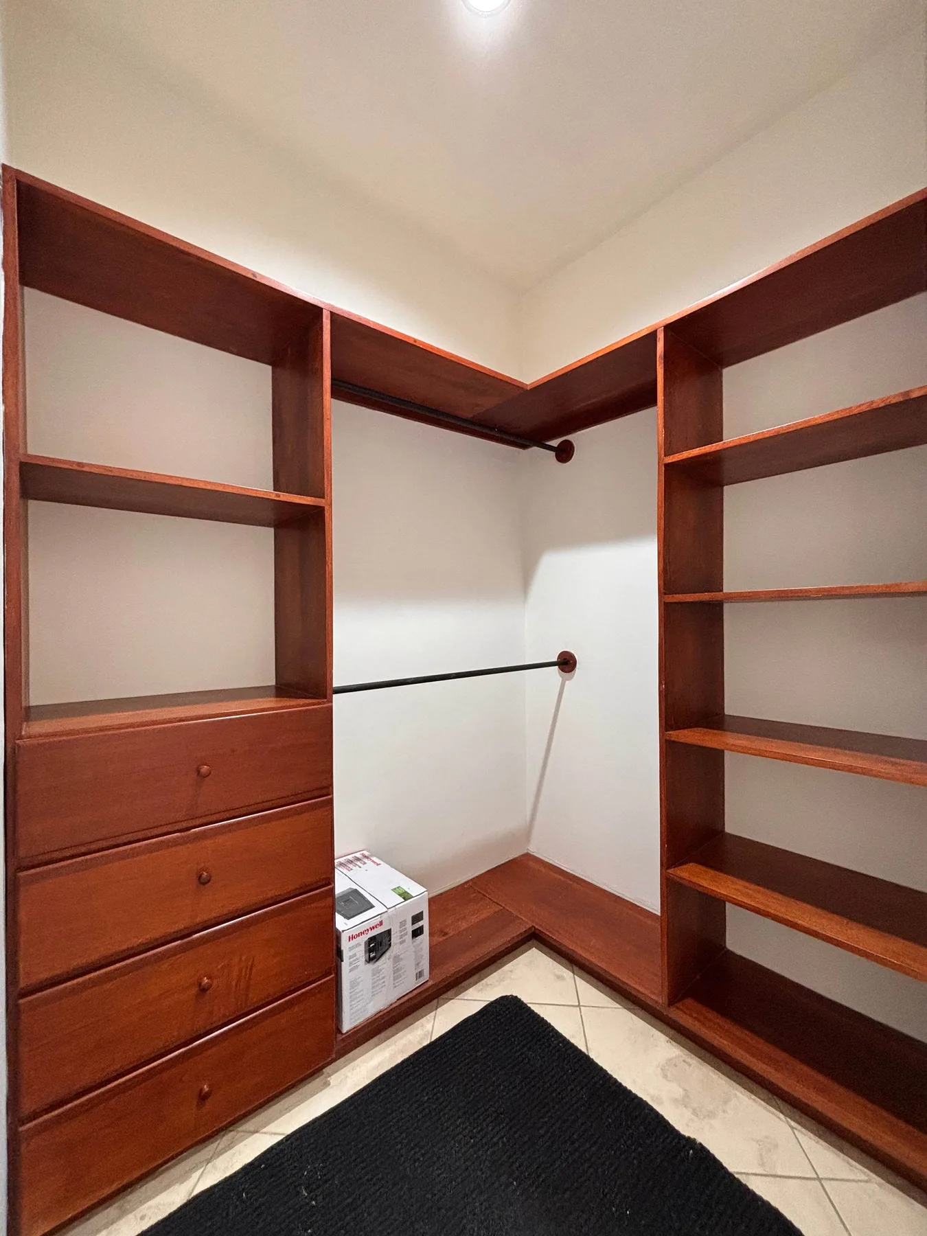 A walk-in closet with built-in shelving and drawers.