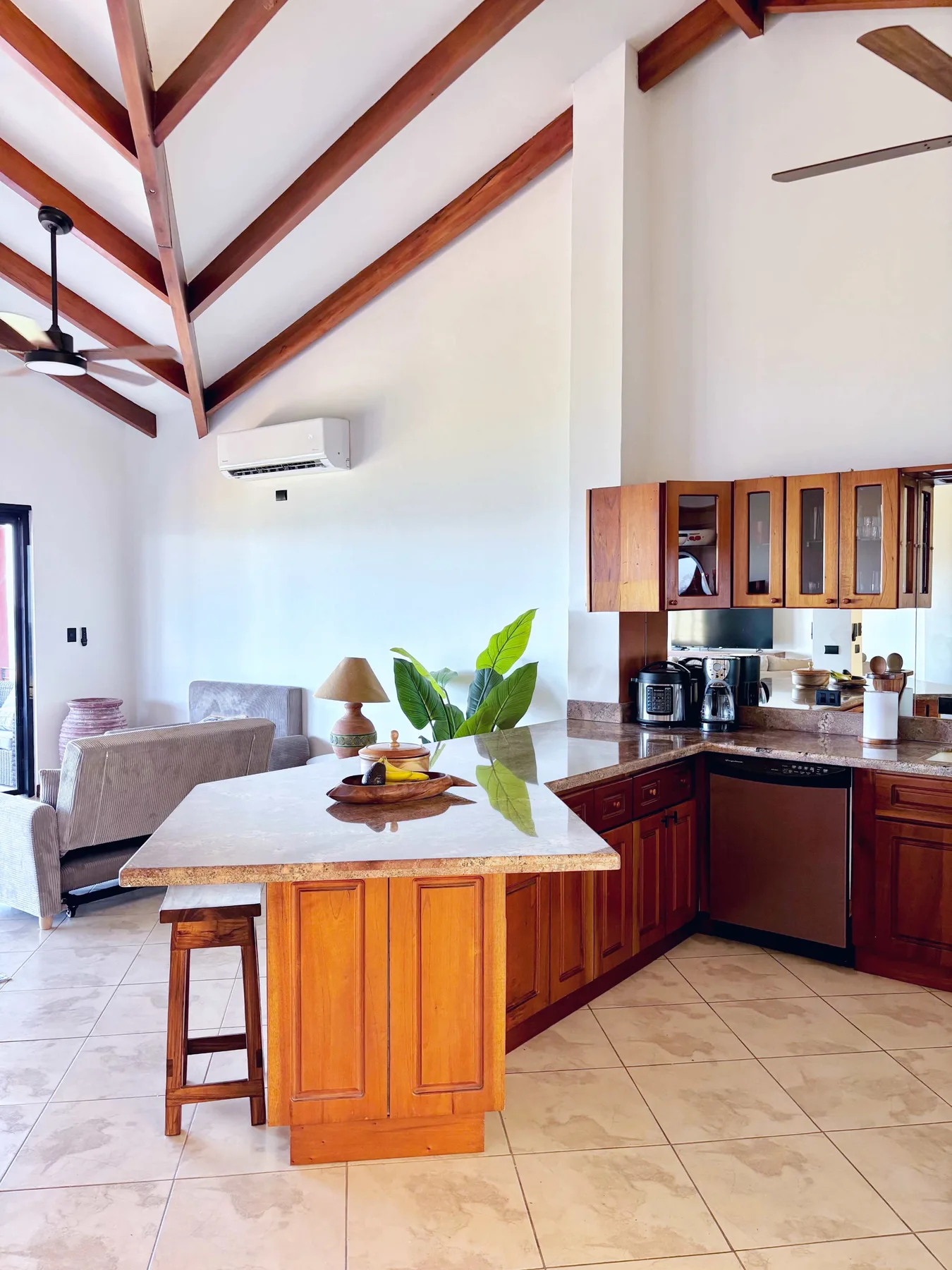 An open-plan kitchen and living area with a wooden island and seating.
