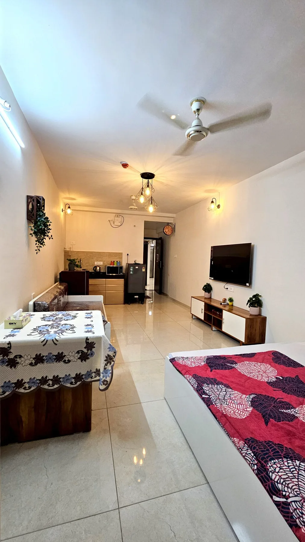 Una sala de estar con televisor, asientos y una mesa de comedor.