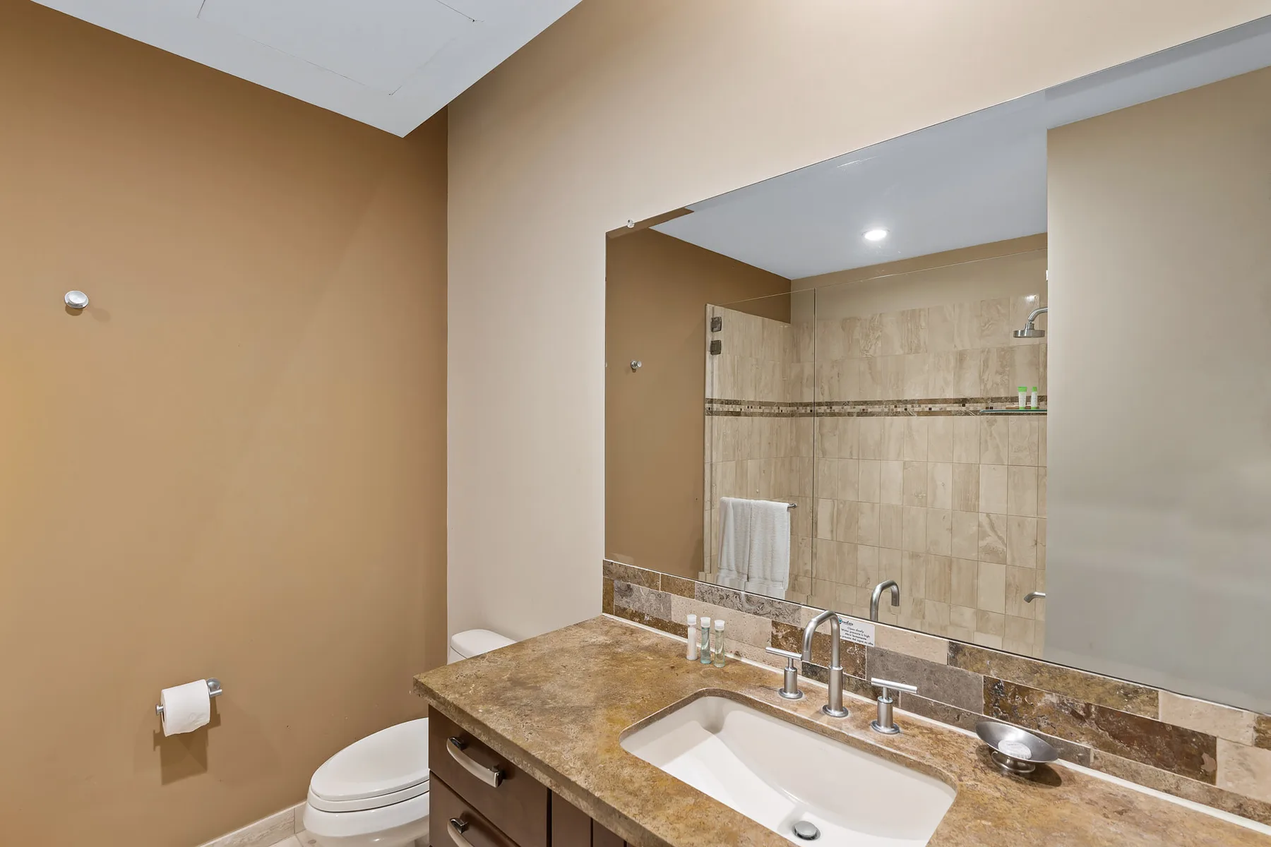 A bathroom vanity with a sink and a large mirror above it.