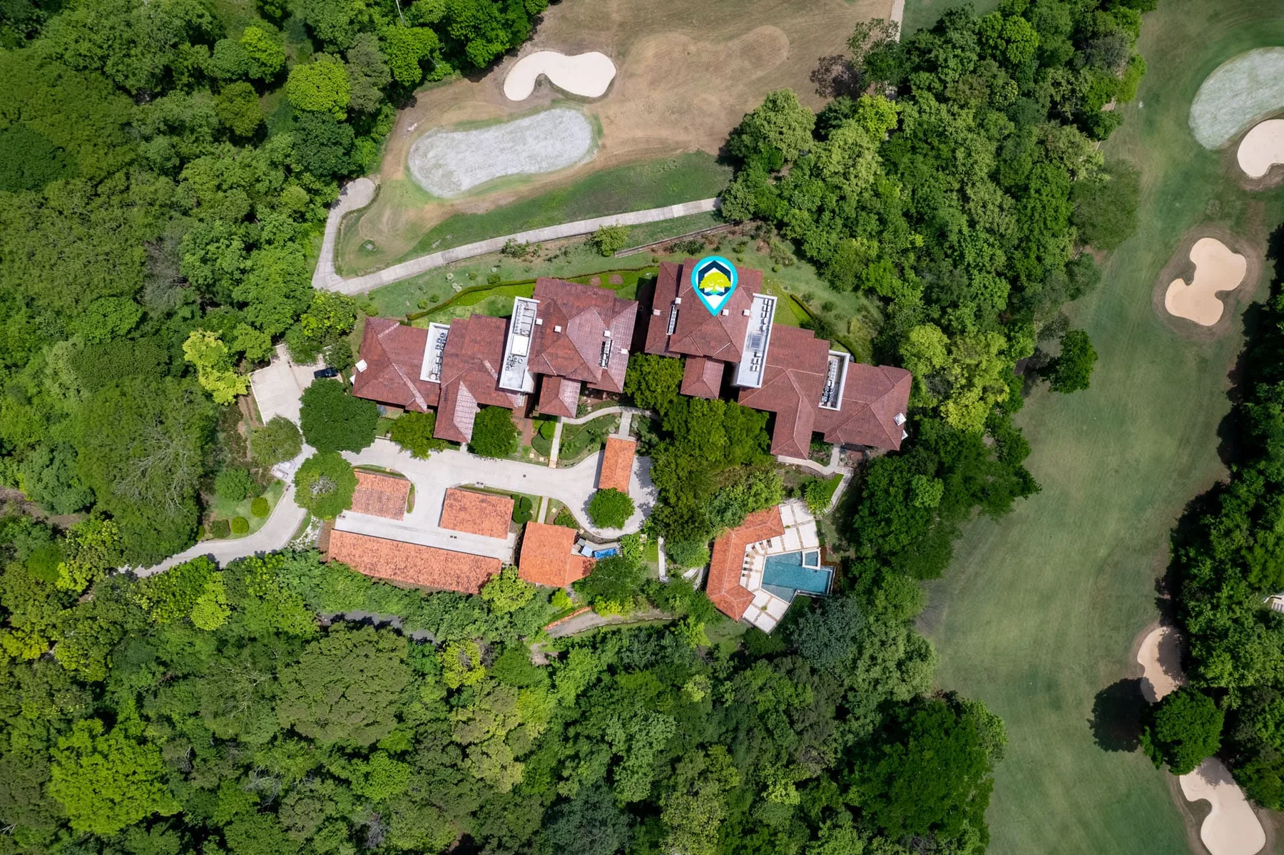 Shared amenity: Aerial view of a building complex surrounded by trees and landscaped grounds.