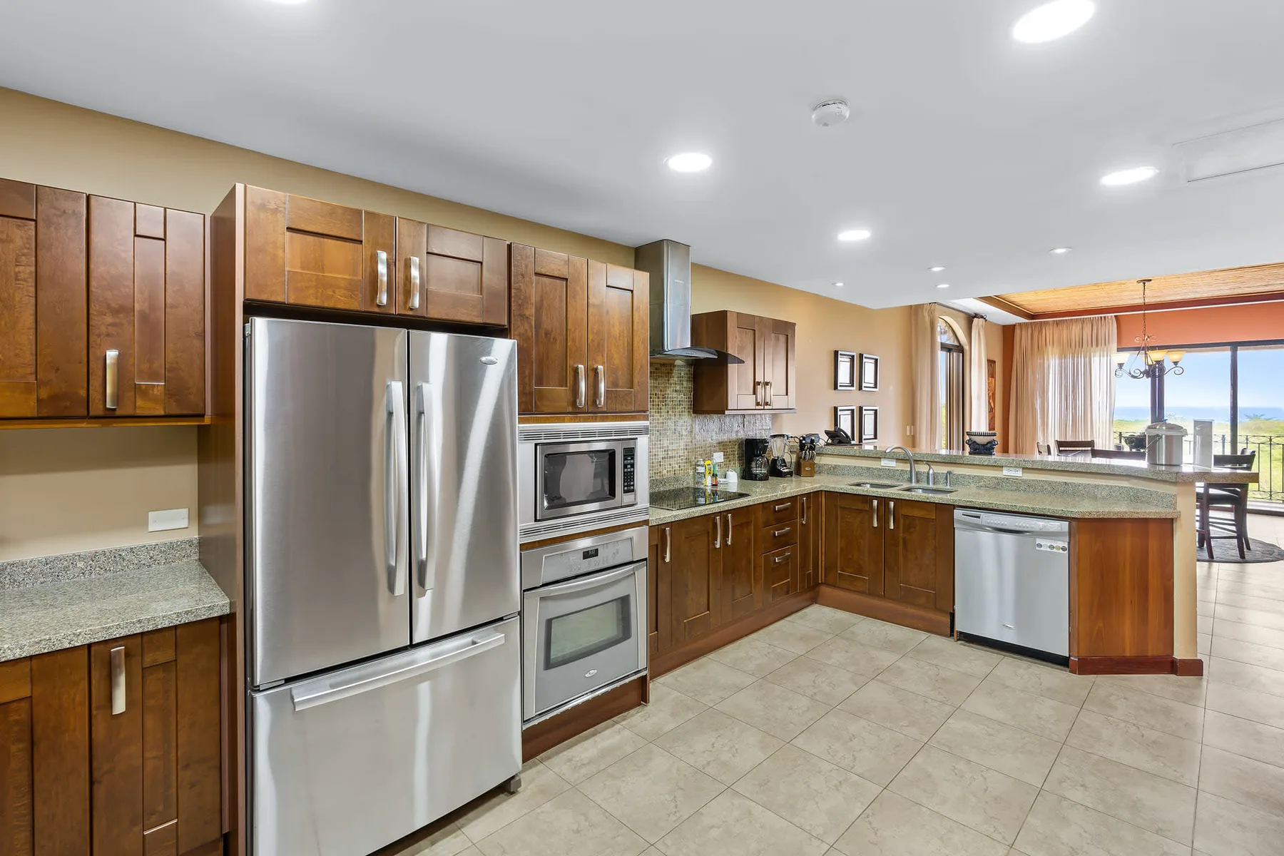 A spacious kitchen with wooden cabinets, stainless-steel appliances, and a central island.