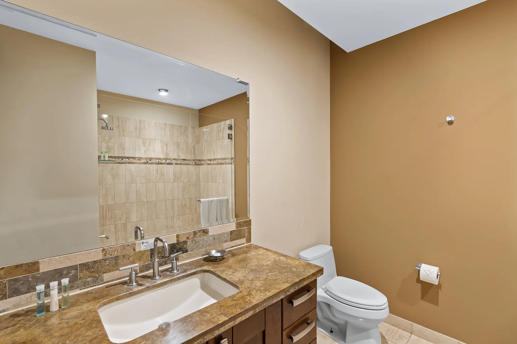A bathroom with a sink, countertop, and toilet.