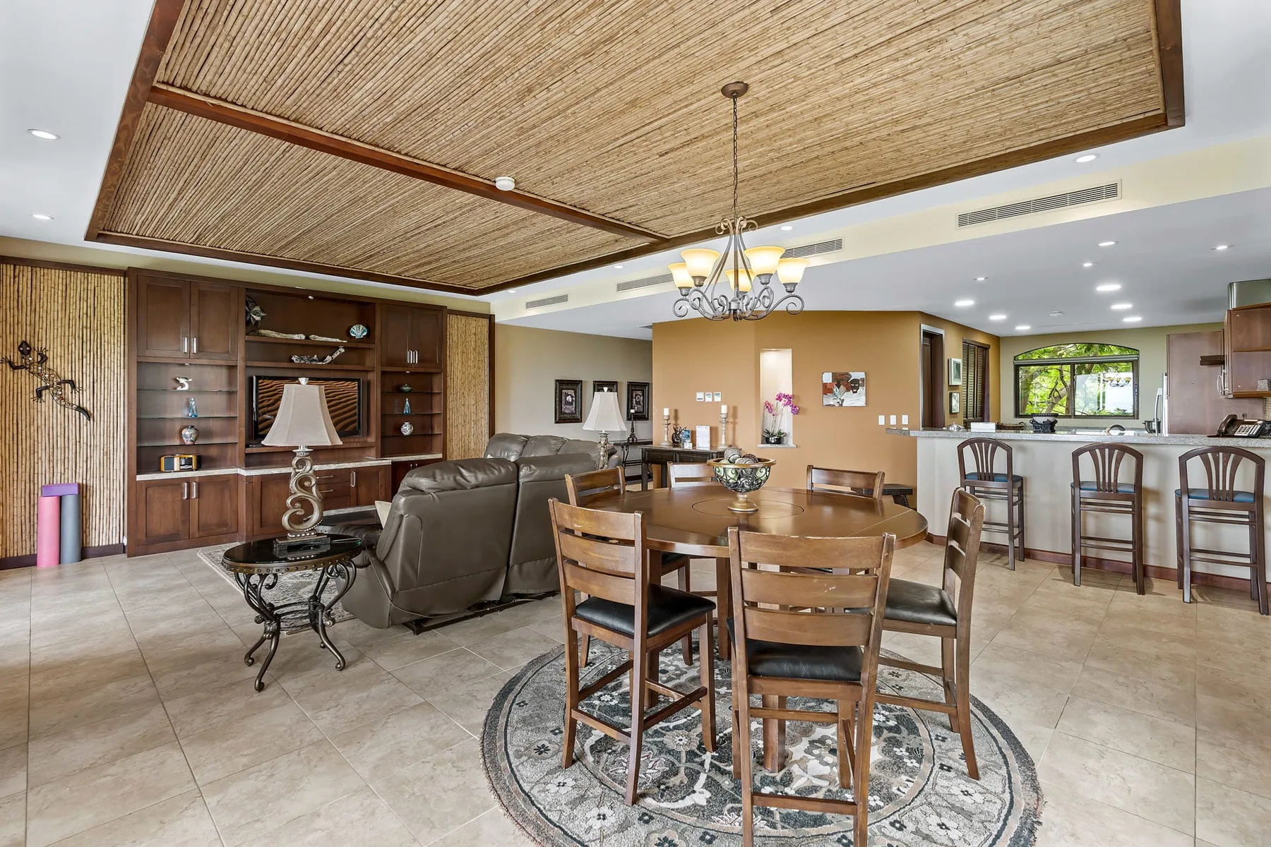 A spacious living and dining area with seating, a wooden table, and a chandelier.