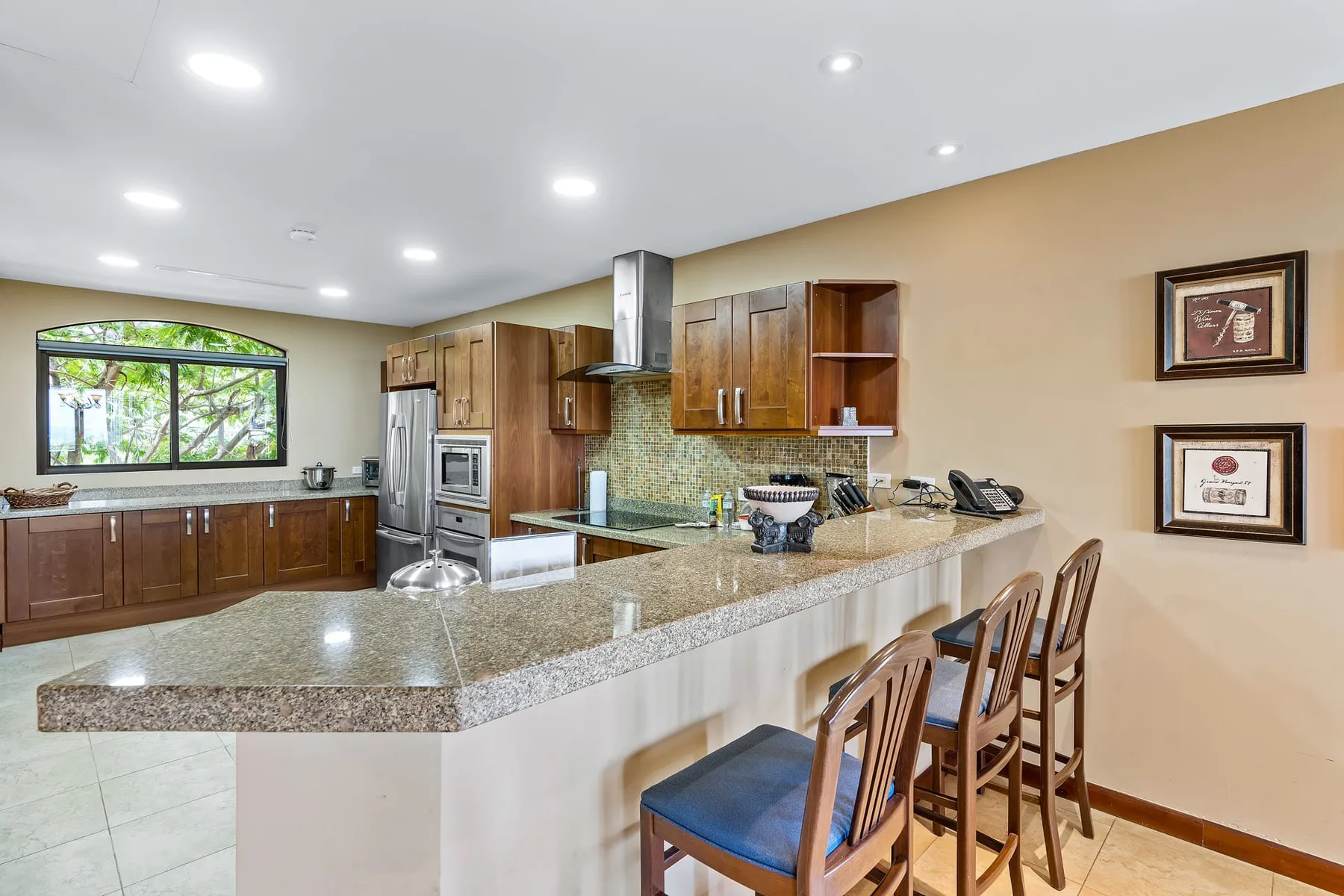 A spacious kitchen with wooden cabinets, stainless steel appliances, and a long island.