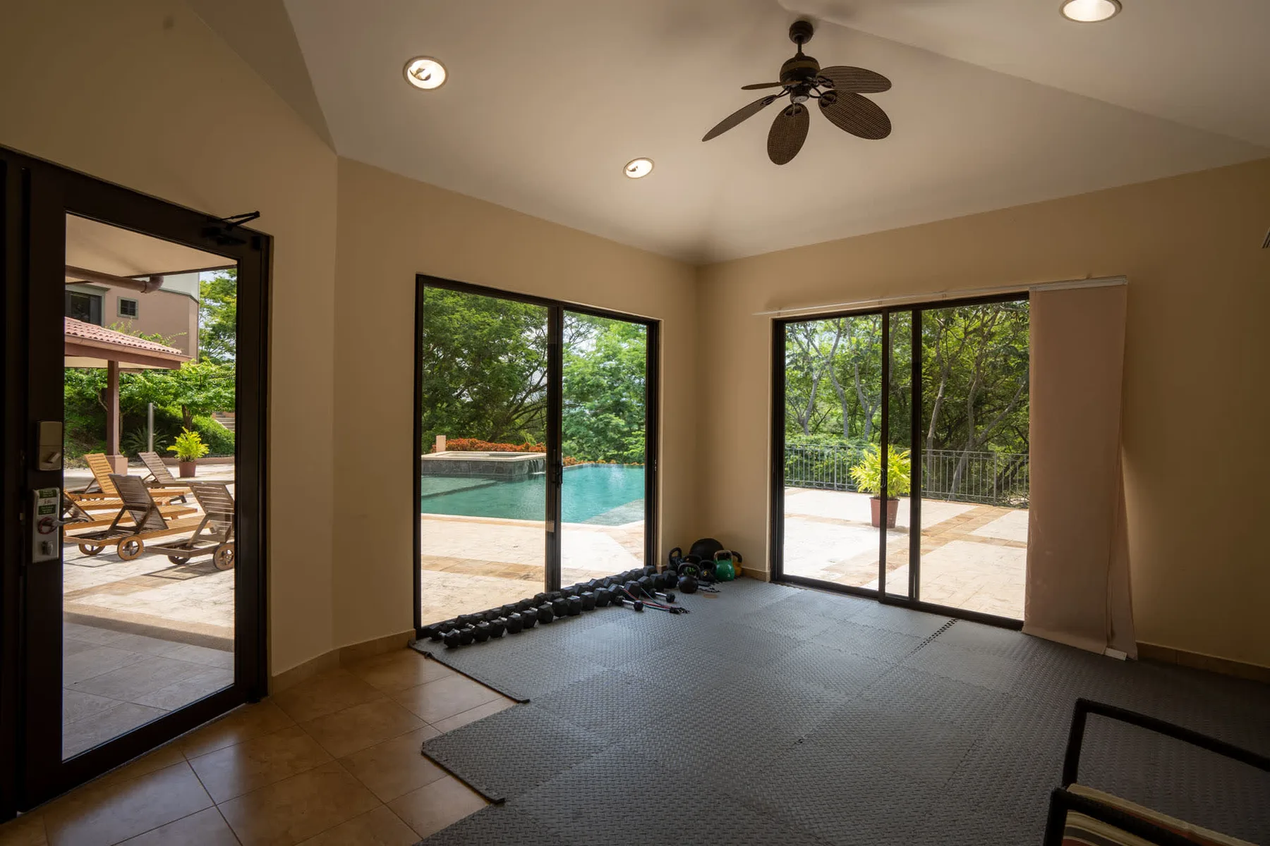 Shared amenity: A bright indoor workout area opens onto a poolside patio.