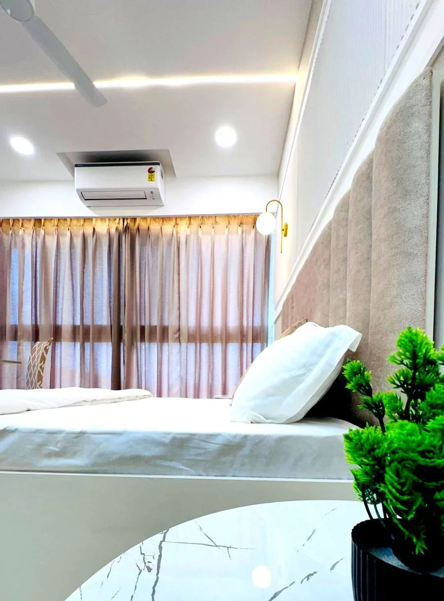 Un dormitorio con una cama tendida y cortinas que cubren la ventana.
