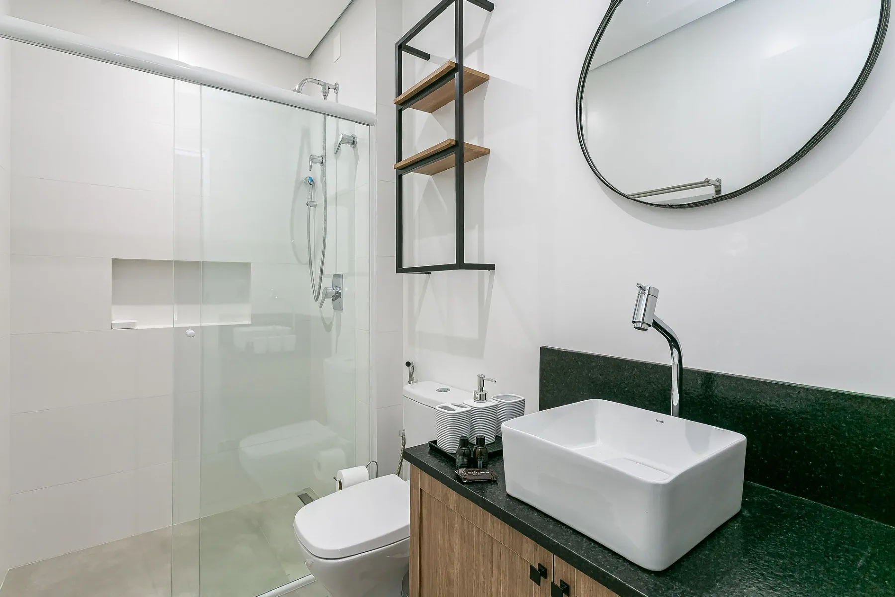 A bright bathroom with a glass shower and a countertop sink.