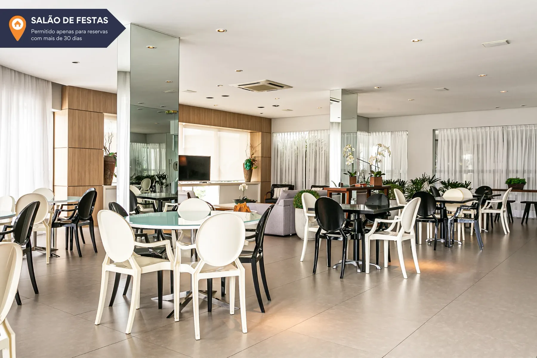 Shared amenity: A dining area with tables and chairs beside large windows.