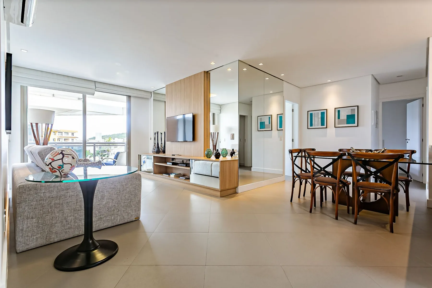 A bright living and dining area with a sofa, television, and dining table.