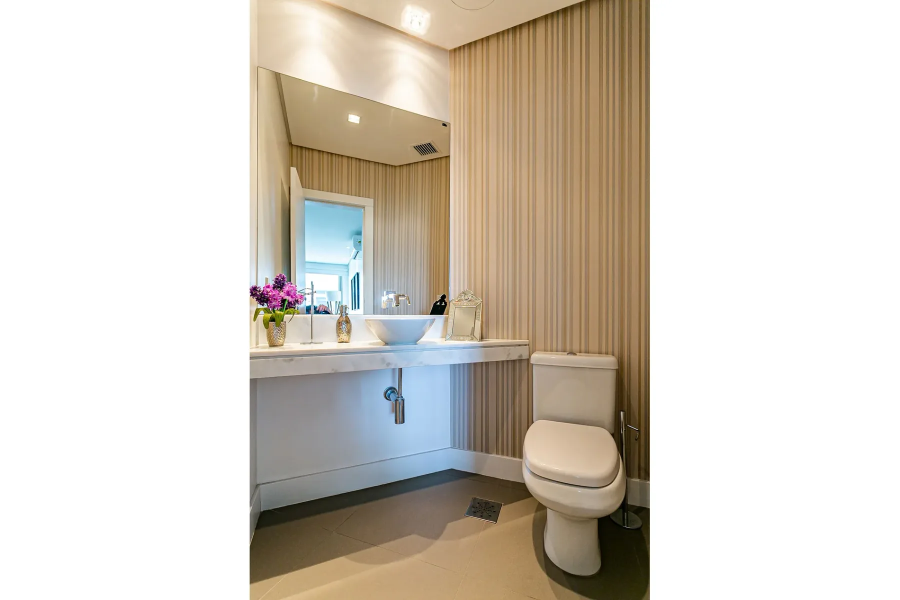 A bathroom with a sink, mirror, and toilet.