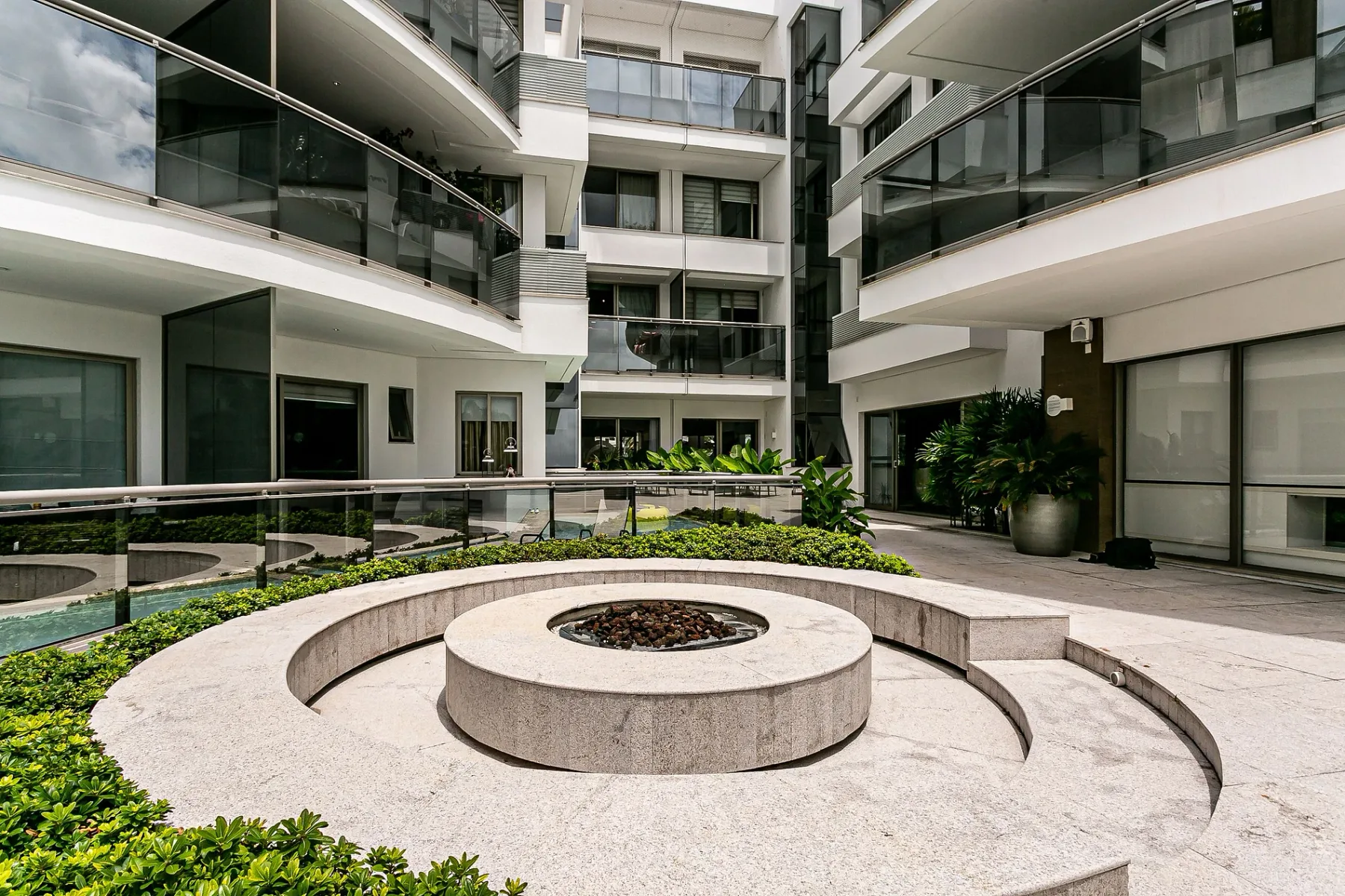 Shared amenity: Residential courtyard with a circular stone seating area and surrounding greenery.