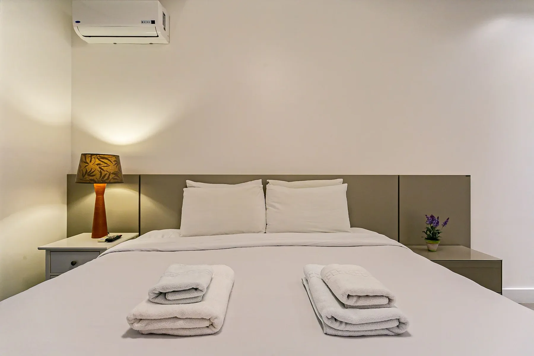 A bedroom with a neatly made bed and bedside tables.