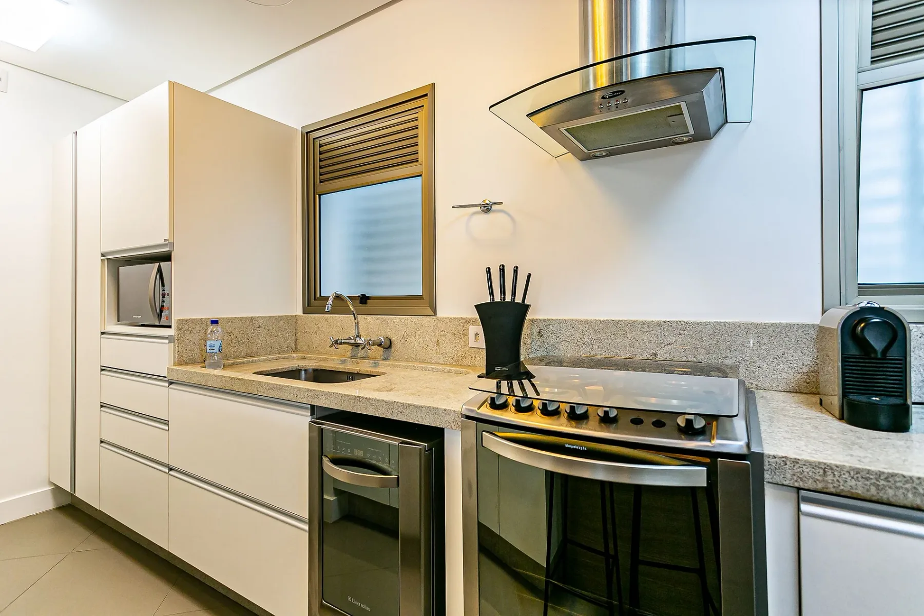 A bright kitchen with a countertop, sink, and stove.