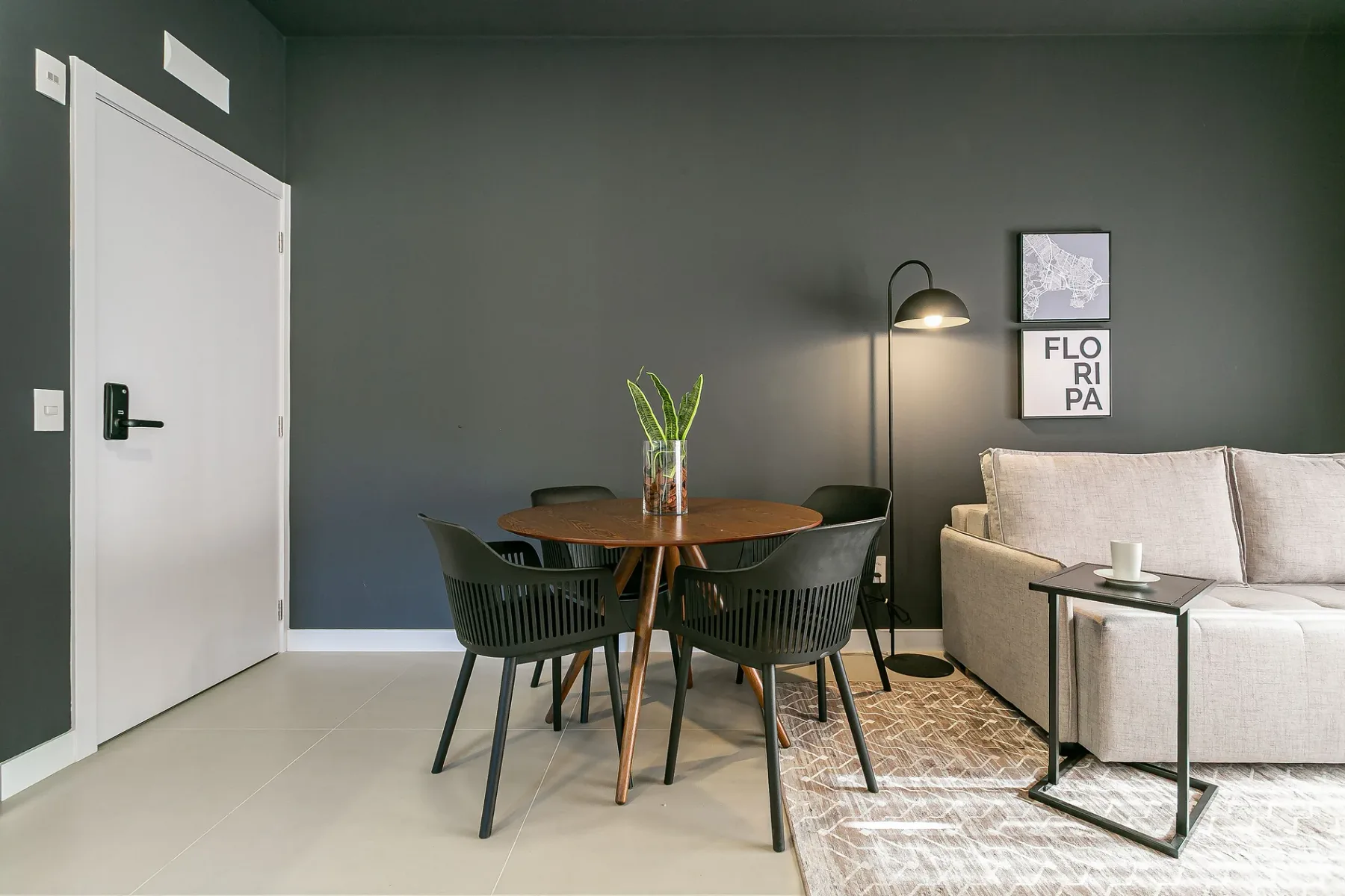 A dining and seating area with a round table, chairs, and a light-colored sofa.