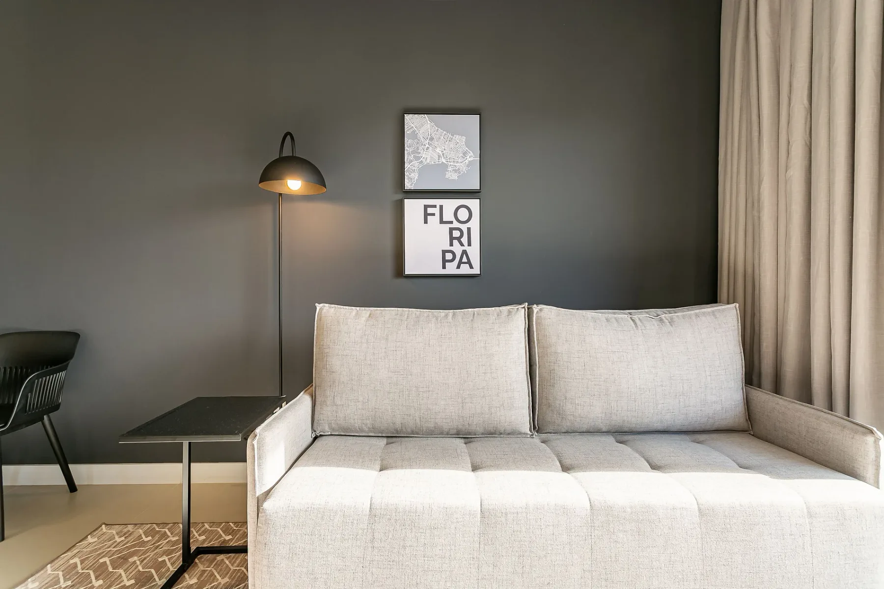 A bright living room with a light-colored sofa and a floor lamp.