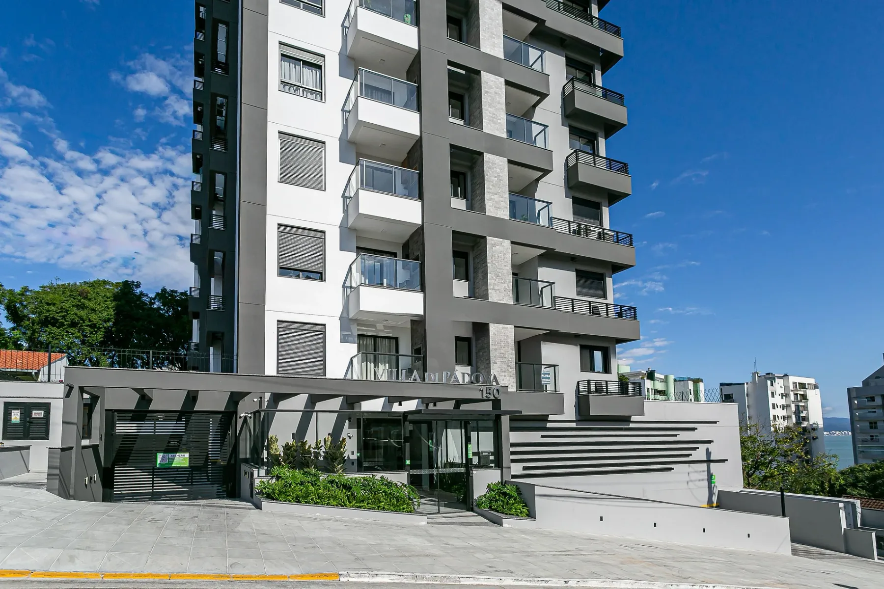 Shared amenity: A modern apartment building stands beside a gated entrance and landscaped frontage.