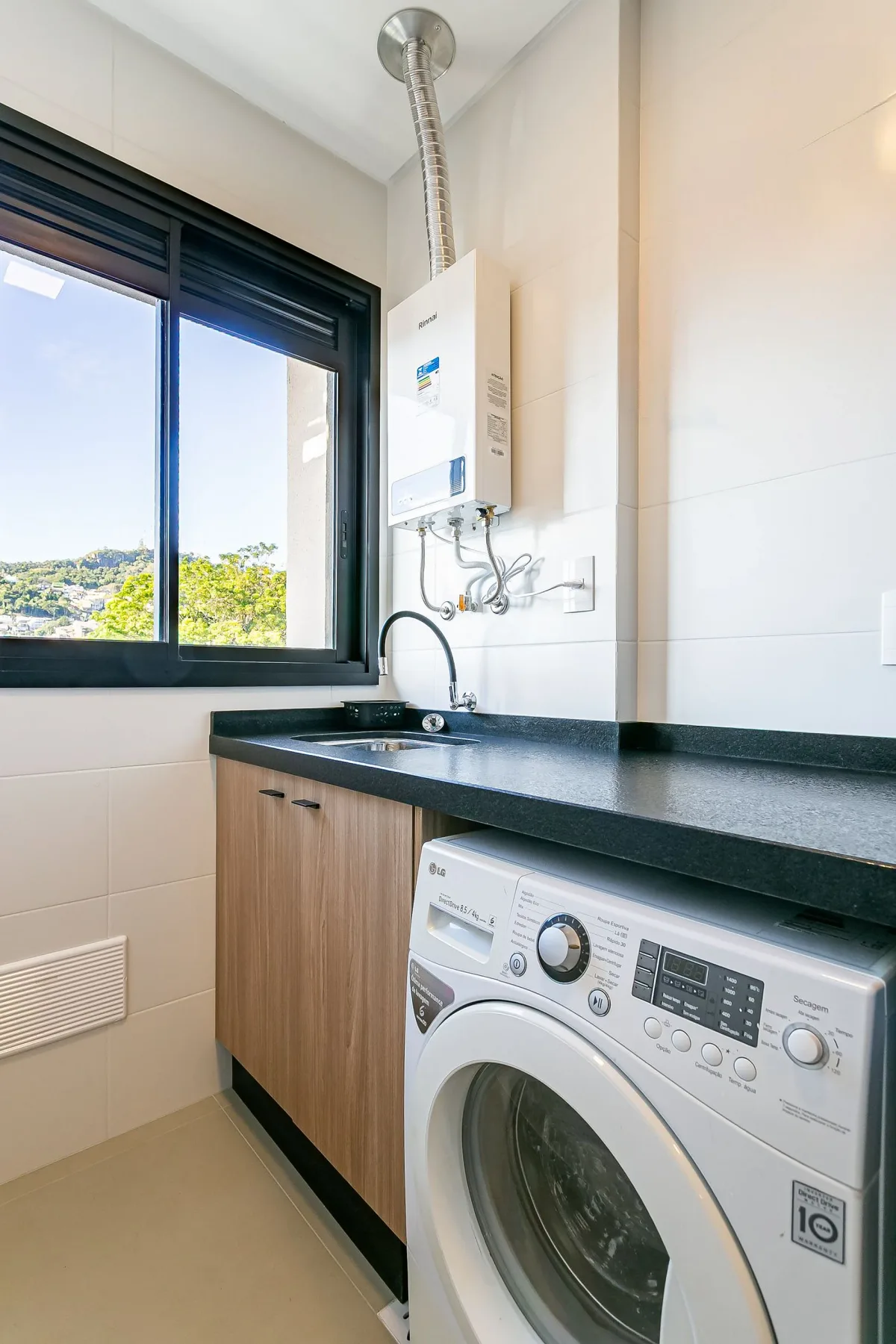 A laundry area with a washing machine beneath a dark countertop.