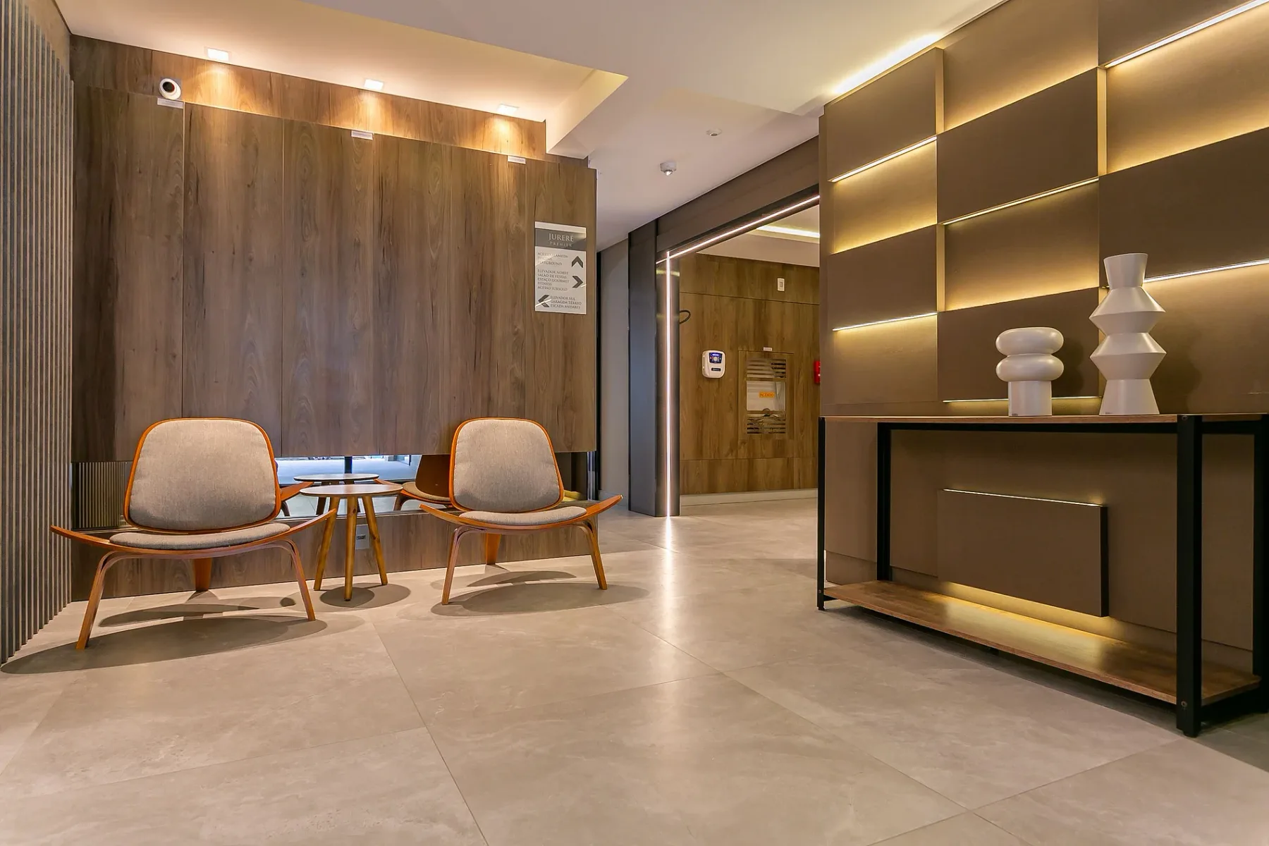 Shared amenity: A modern lobby seating area with warm illuminated wall shelving.