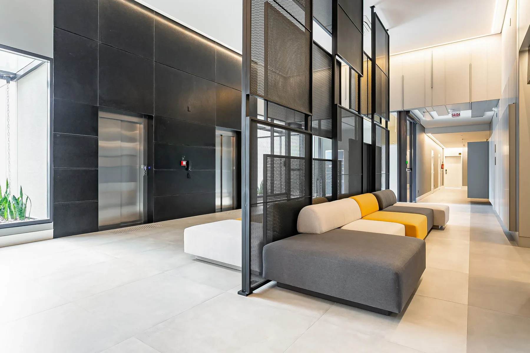Shared amenity: A modern lobby with seating beside the elevator.