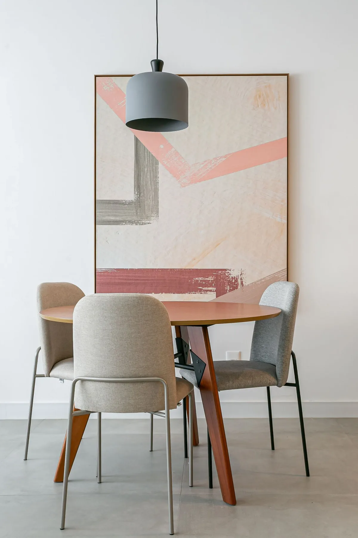 A dining area with a table, chairs, and a large abstract artwork on the wall.