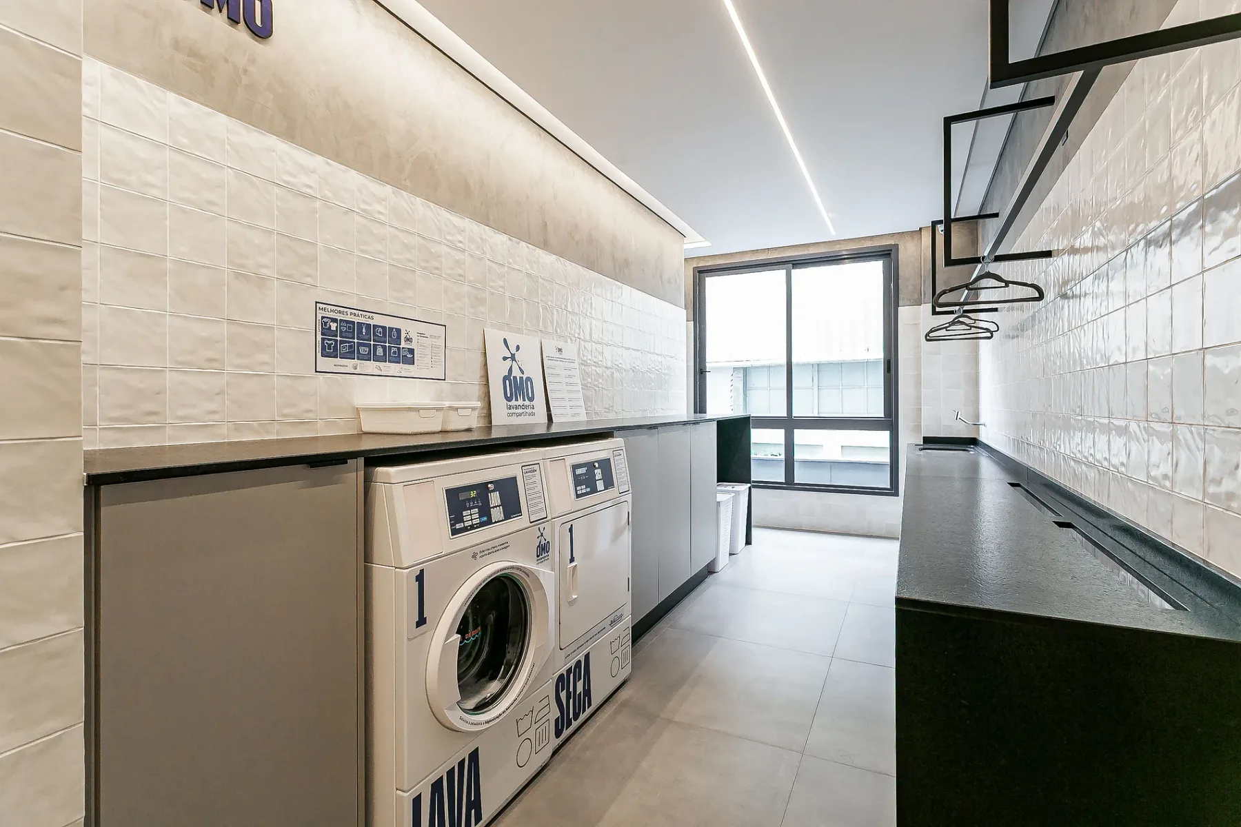 Shared amenity: Laundry room with washing machines and a long folding counter.